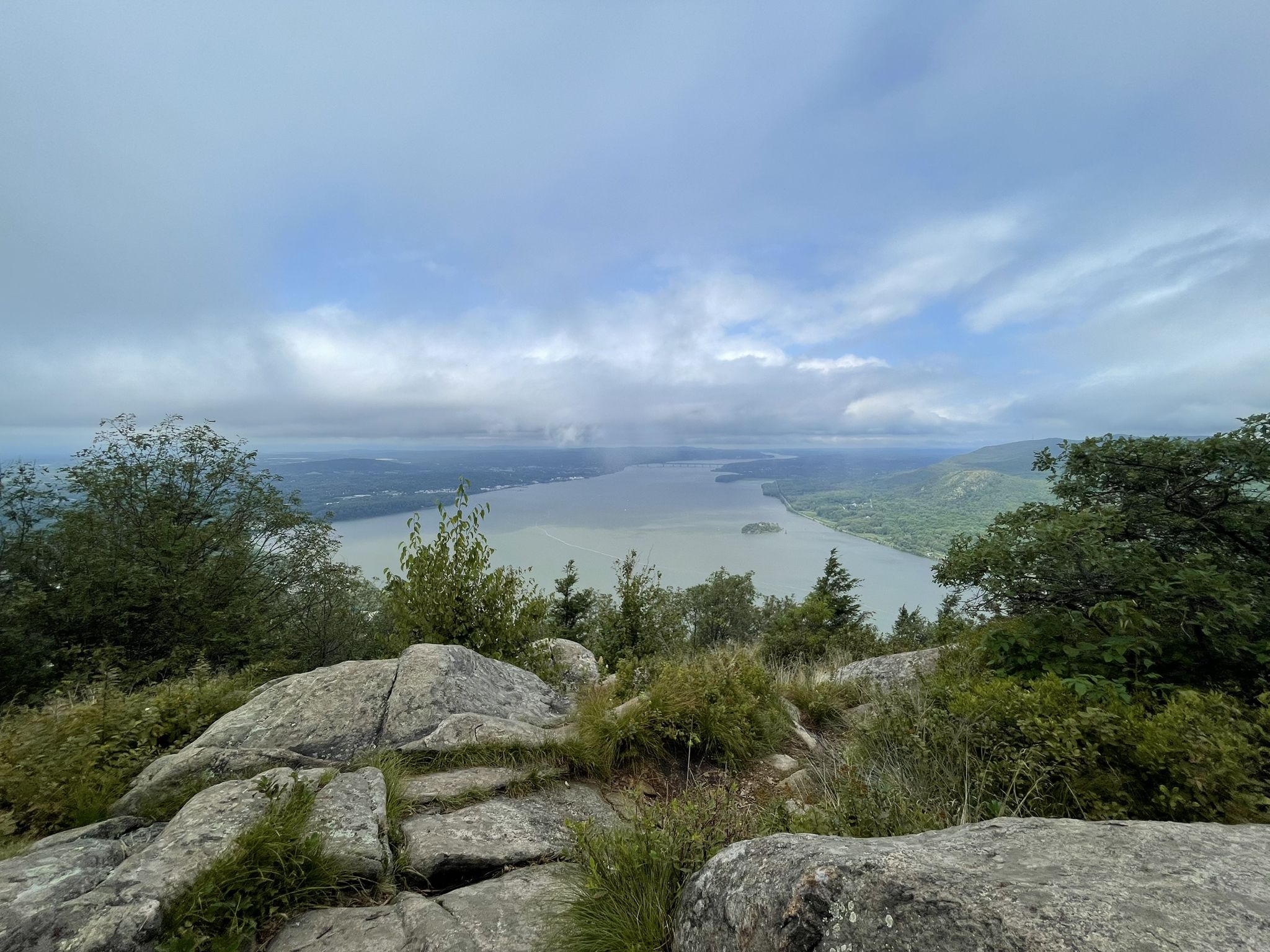 Overcast view from a rocky summit overlooking a large body of water. - Storm King Mountain via Bayview Avenue