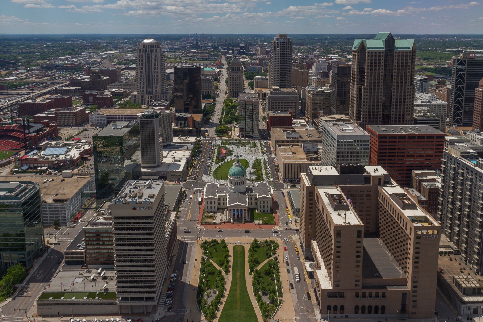 Aerial view of a bustling city with skyscrapers and a central domed building. - Gateway Arch Trail