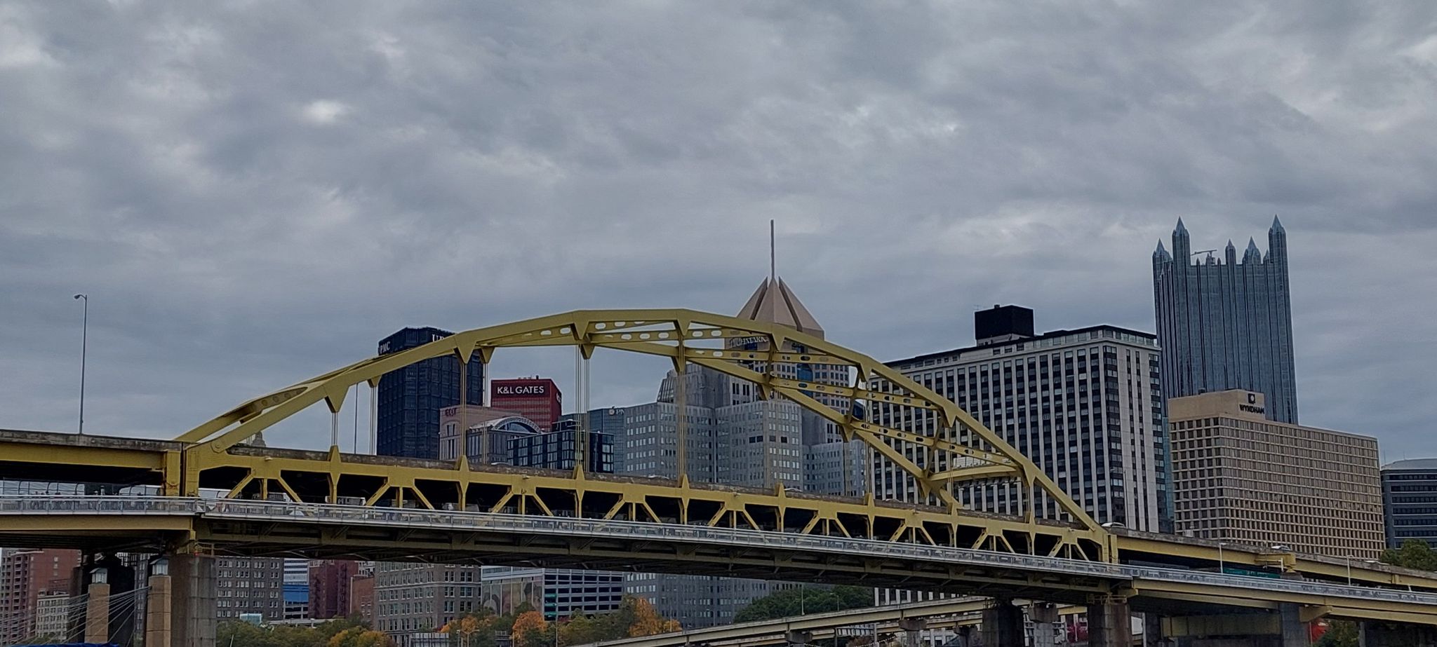 Yellow bridge and city skyline under a dramatic cloudy sky. - Chateau Trail – North Shore Riverfront Park loop from Brunot Island