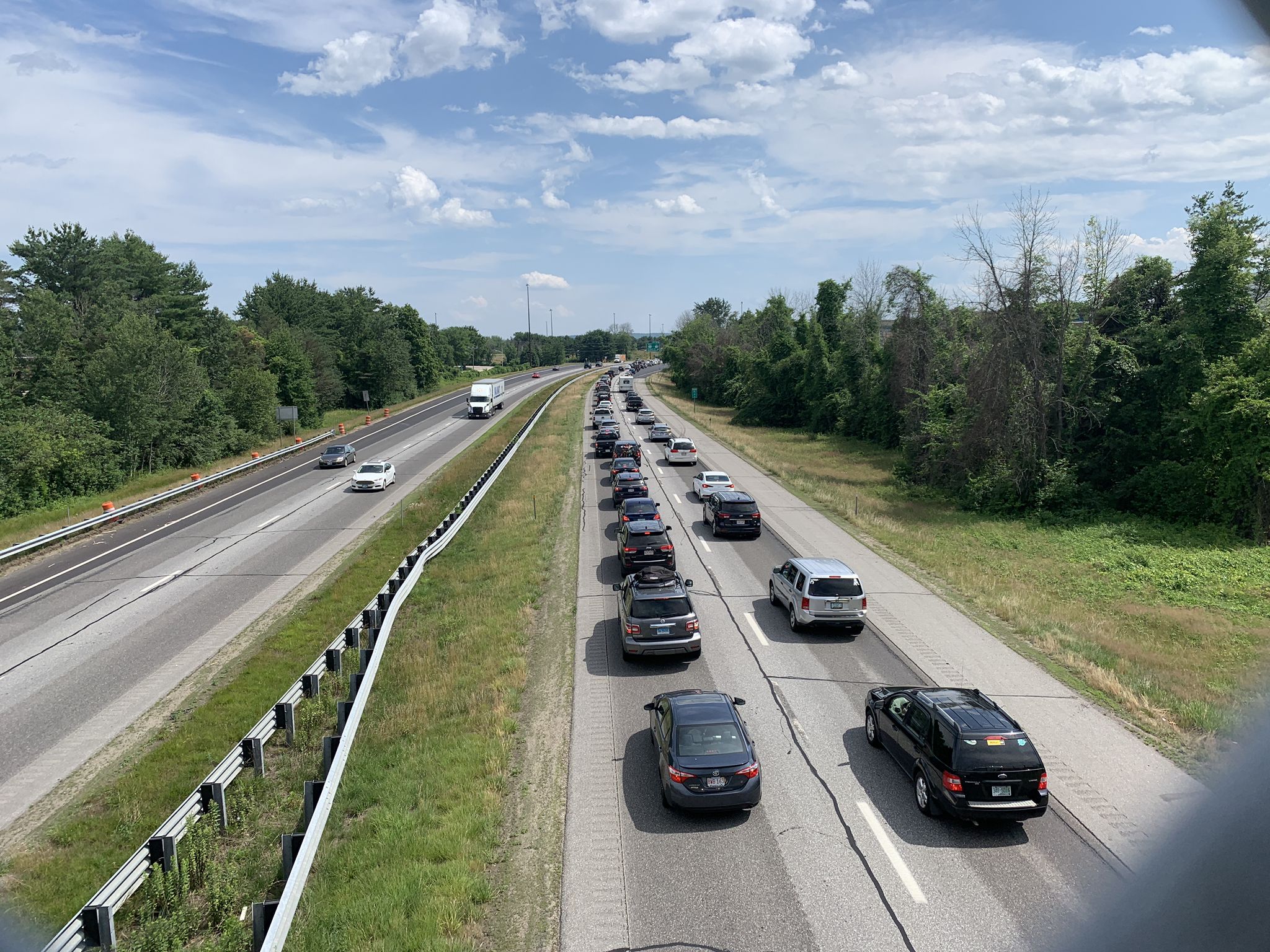 Bright daylight on a highway with heavy traffic and green trees. - White Park – New Hampshire State Capitol loop from Saint Pauls School