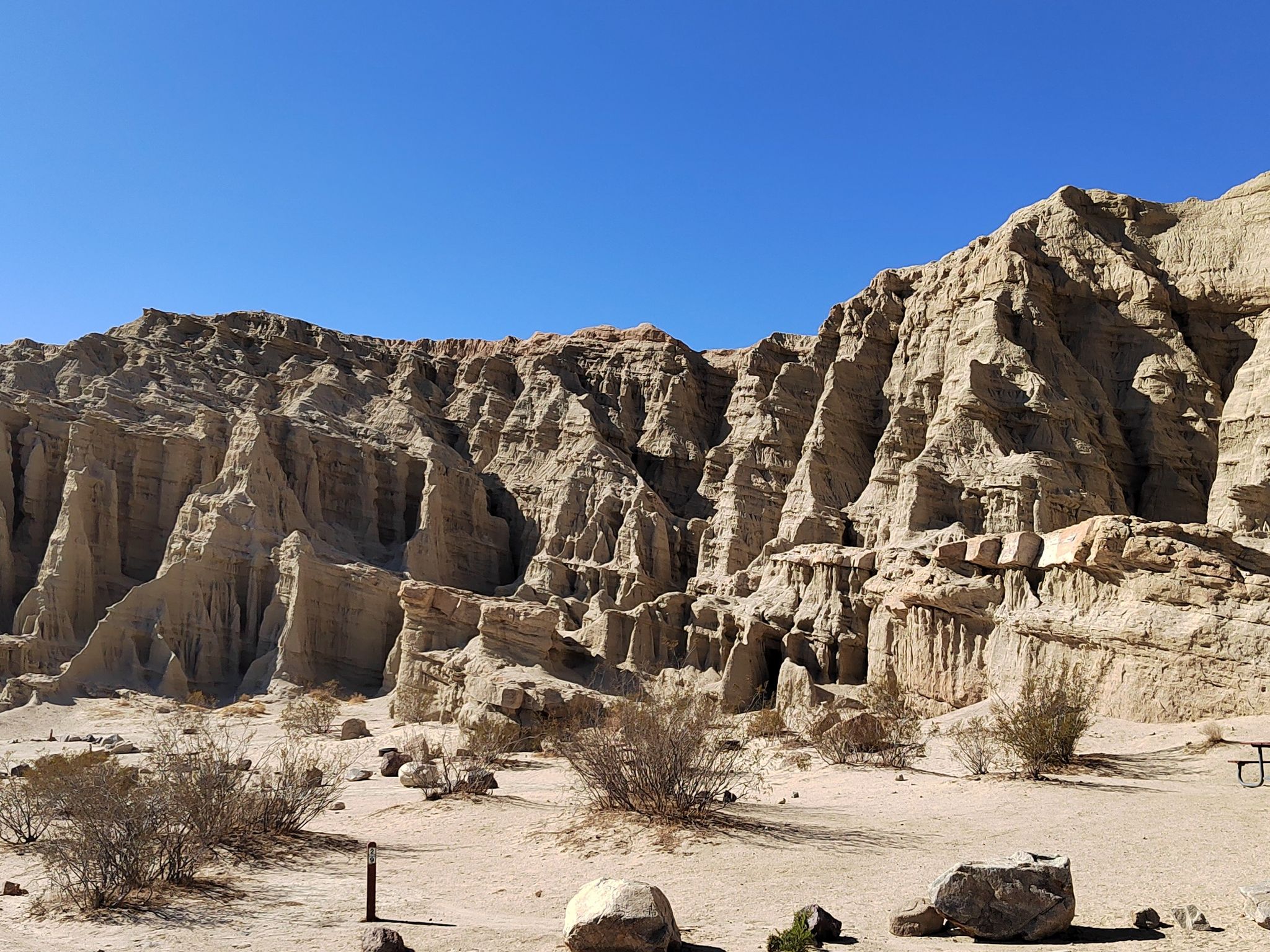 Towering light-colored rock formations under a bright clear blue sky. - Ricardo Campground