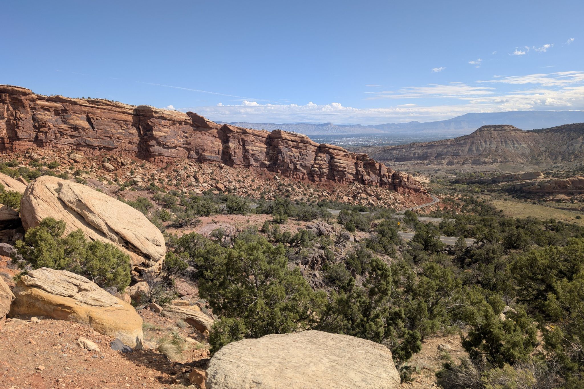 Expansive view of red rock cliffs and green desert shrubs. - Kids Meal Trail – Rim Rock Drive loop from Colorado Mesa University