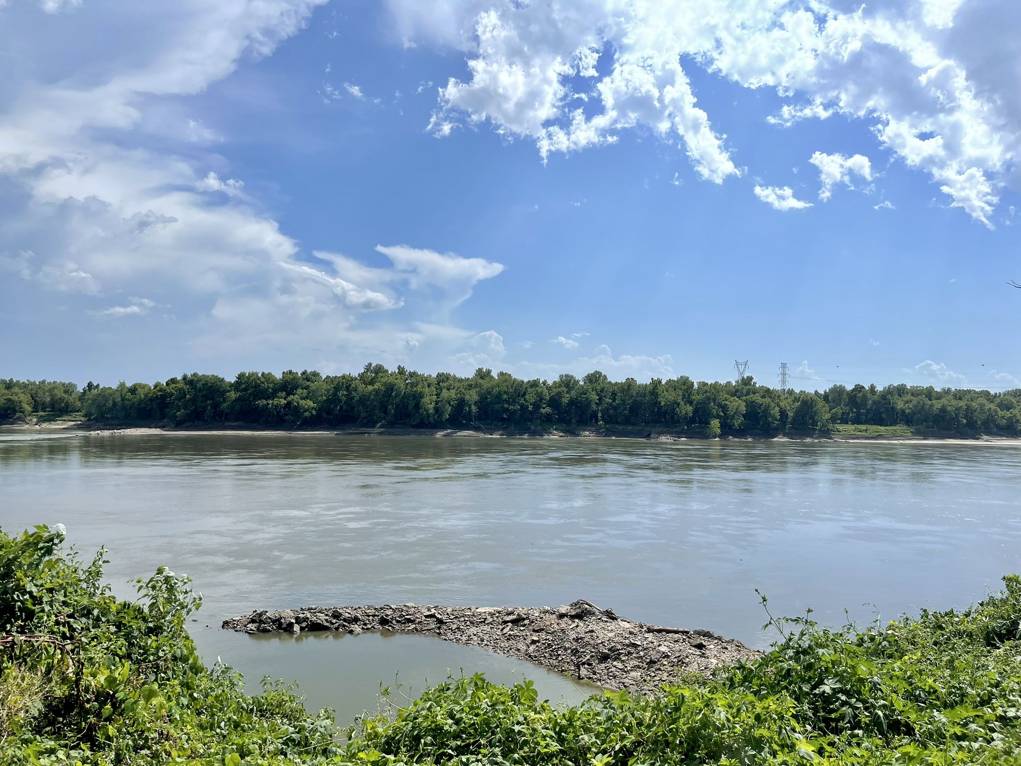 Wide river with a forested island under a bright, cloudy sky. - Katy Trail: Jefferson City to Hermann