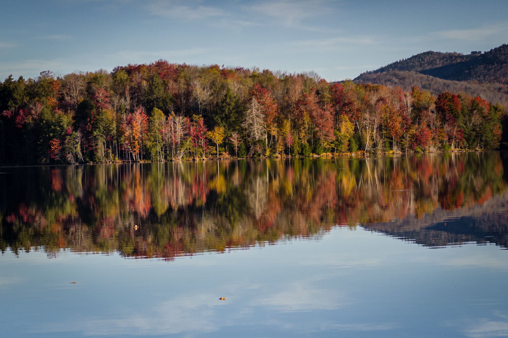Calm lake reflecting vibrant autumn trees under a bright sky. - South Kent Pond via Appalachian Trail