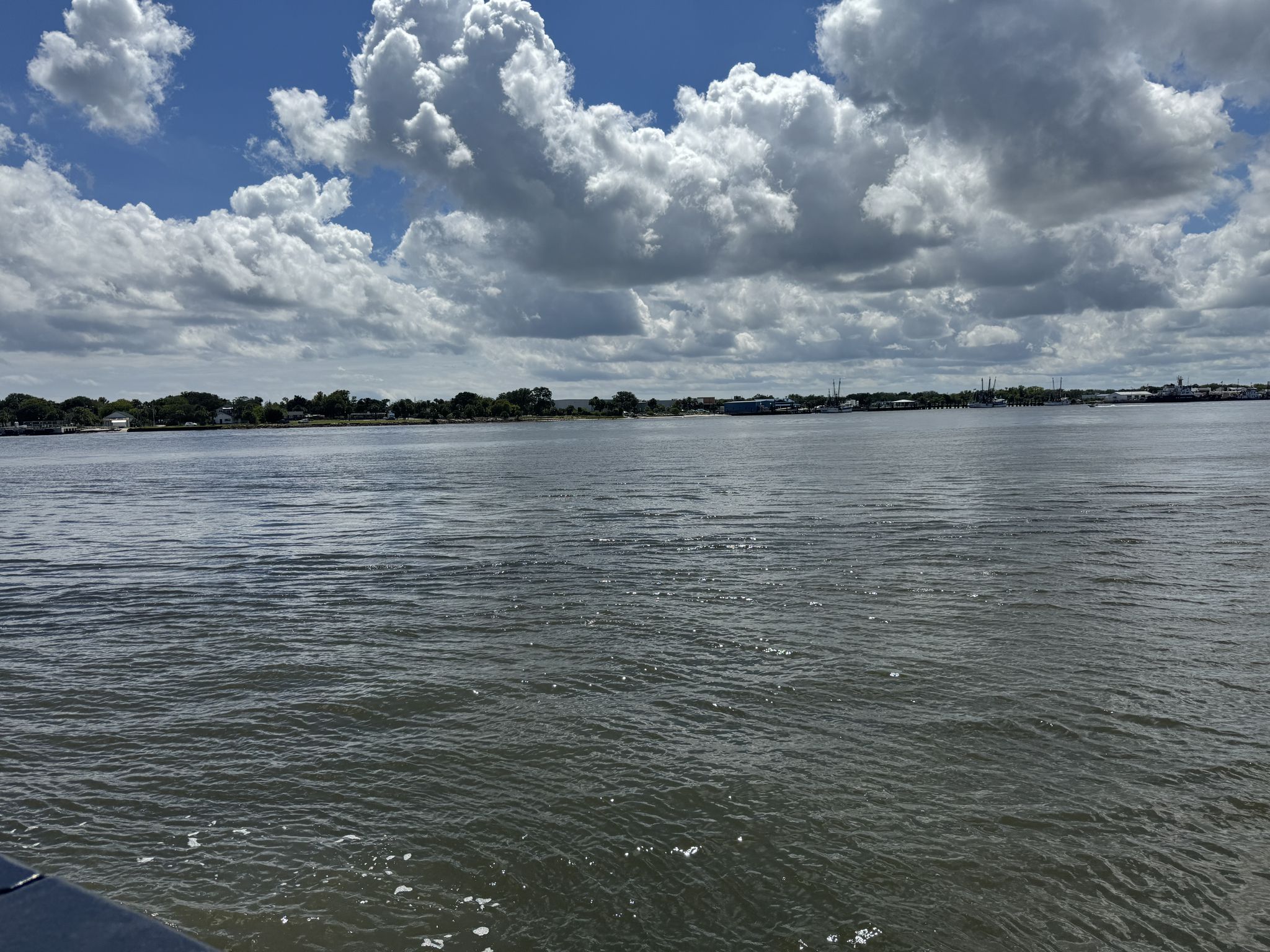 Wide river under a partly cloudy sky, with distant shoreline and buildings. - St. Johns River Ferry – Buccaneer Trail loop from Boathouse Islands