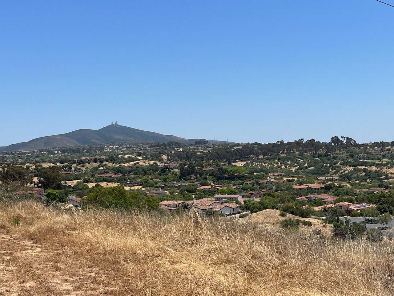 Sunny view of a distant mountain over a residential area and dry hills. - Gravel loop from Intuit Inc.