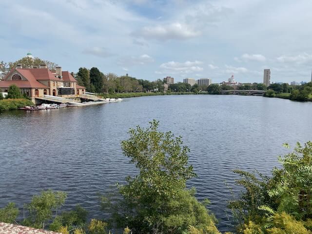 Wide river with buildings and trees under a cloudy daytime sky. - Dr. Paul Dudley White Path