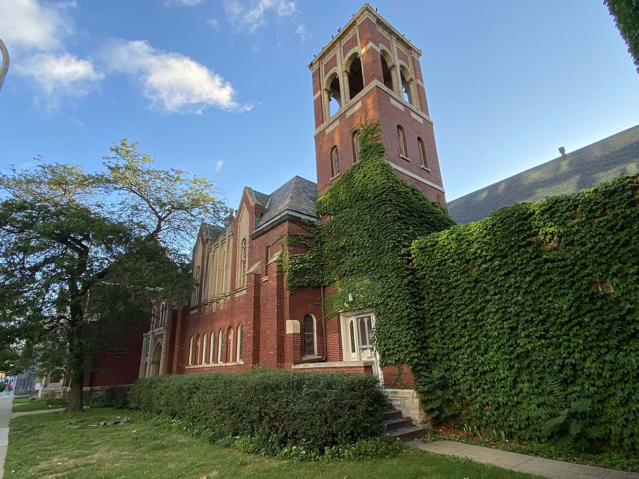 Historic brick building with a bell tower and ivy under a blue sky. - Green Bay Trail – Grosse Point Lighthouse loop from Evanston Main Street