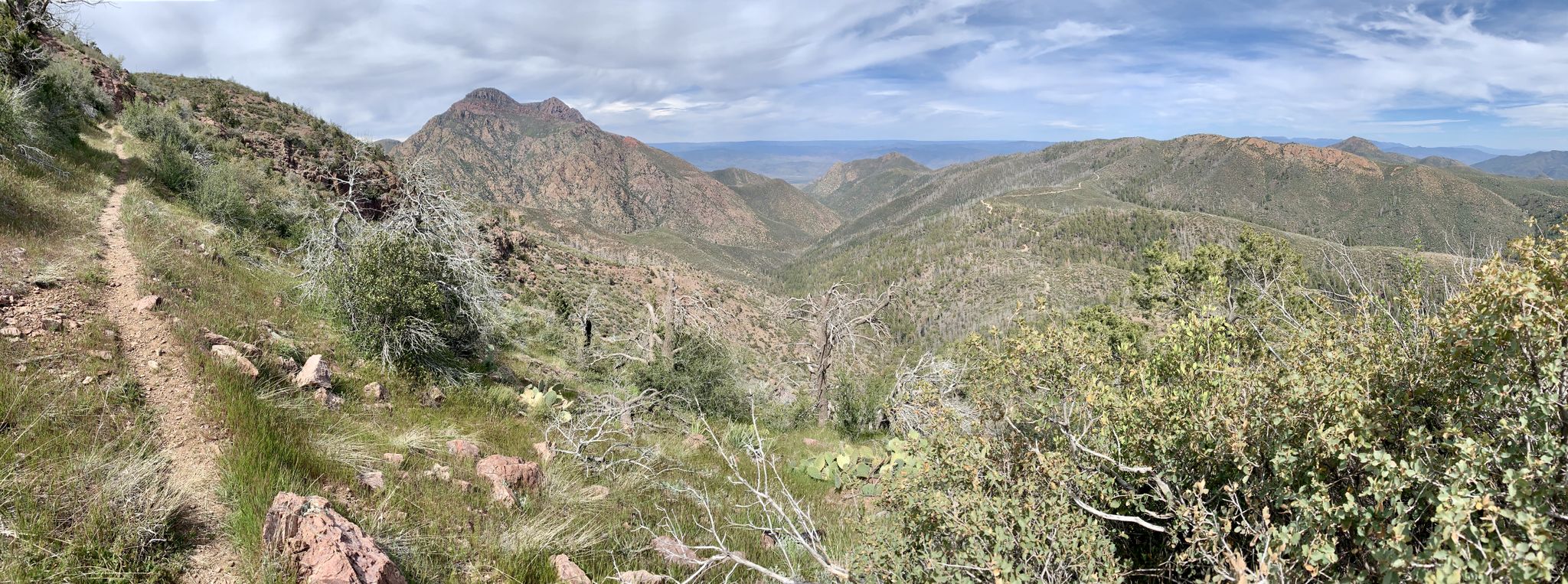 Panoramic view of a winding dirt trail through arid mountains under a cloudy sky. - Arizona Trail: Passage 23 - Mazatzal Divide