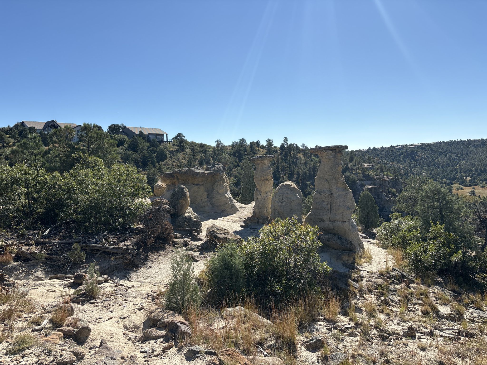 Tall hoodoo rock formations stand in a sunny, arid landscape. - Pulpit Rock Peak Loop
