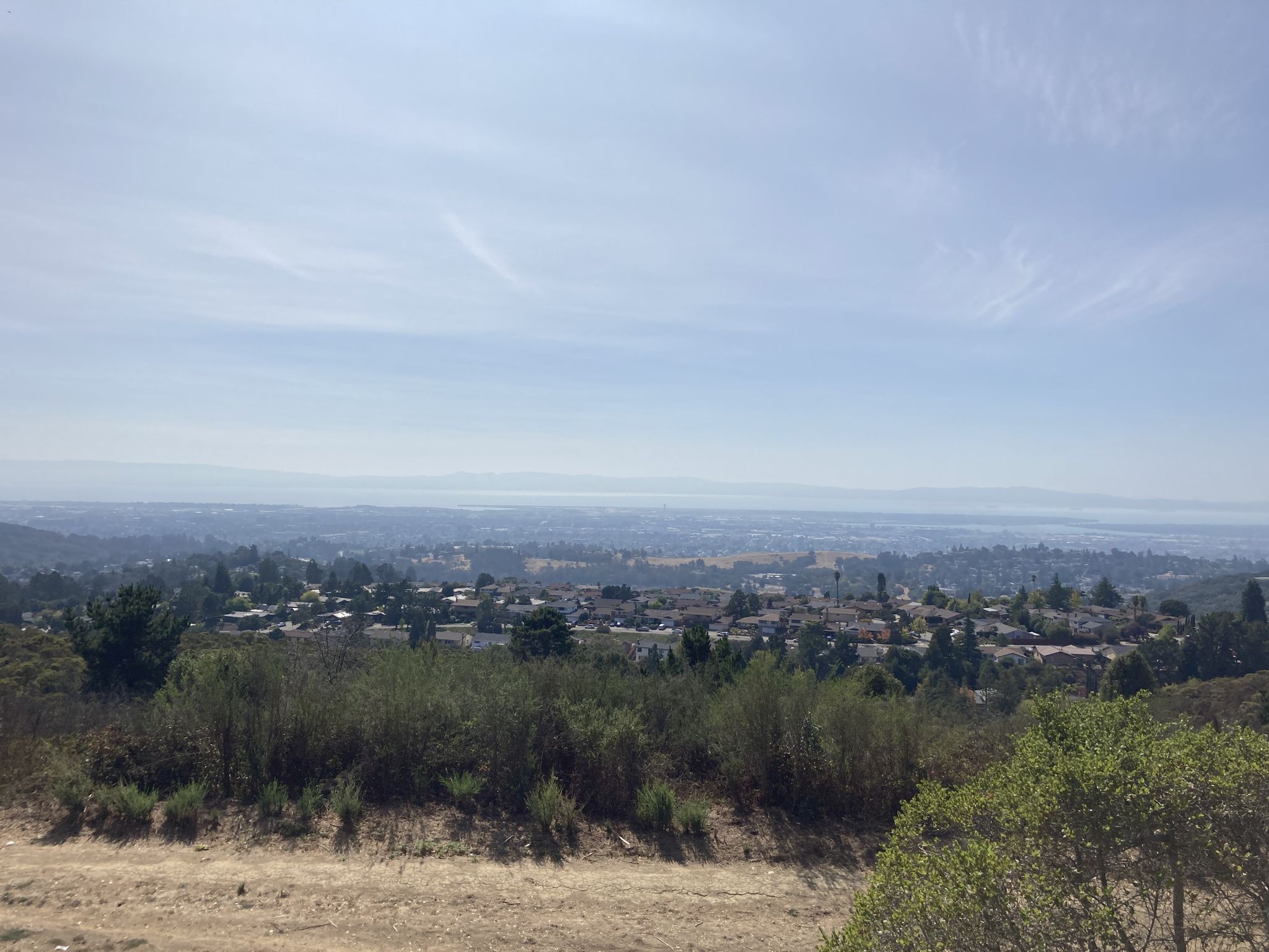 Panoramic view of a distant city and valley under a hazy sky. - Butters Canyon – Equestrian Center loop from Mills College at Northeastern University
