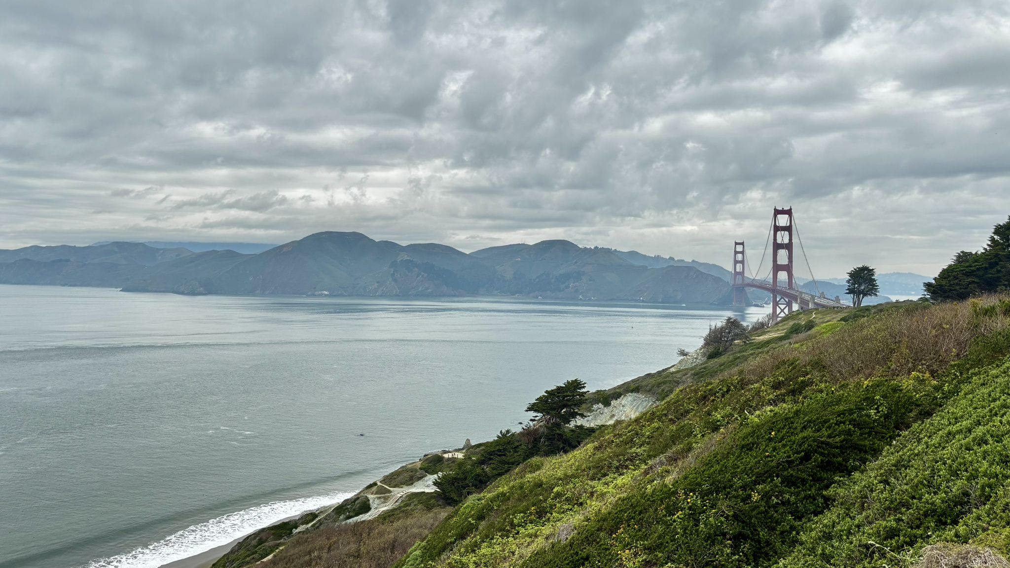 Overcast view of a large bay, distant mountains, and a red bridge. - Presidio Arguello Gate – Inspiration Point 🌲 loop from Carl Street & Cole Street