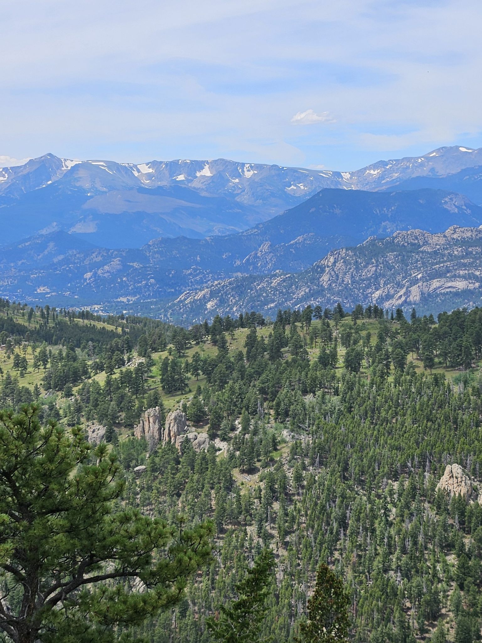 Layers of forested mountains and distant snow-capped peaks under a cloudy sky. - Crosier Mountain Loop