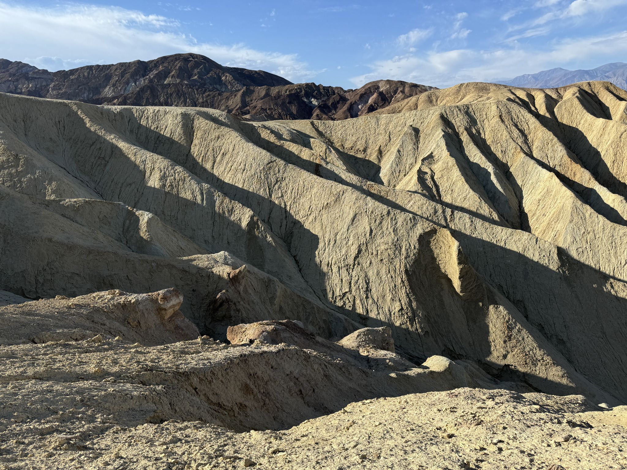 Eroded desert hills with strong shadows and bright sunlight under a blue sky. - Golden Canyon and Gower Gulch Loop Trail