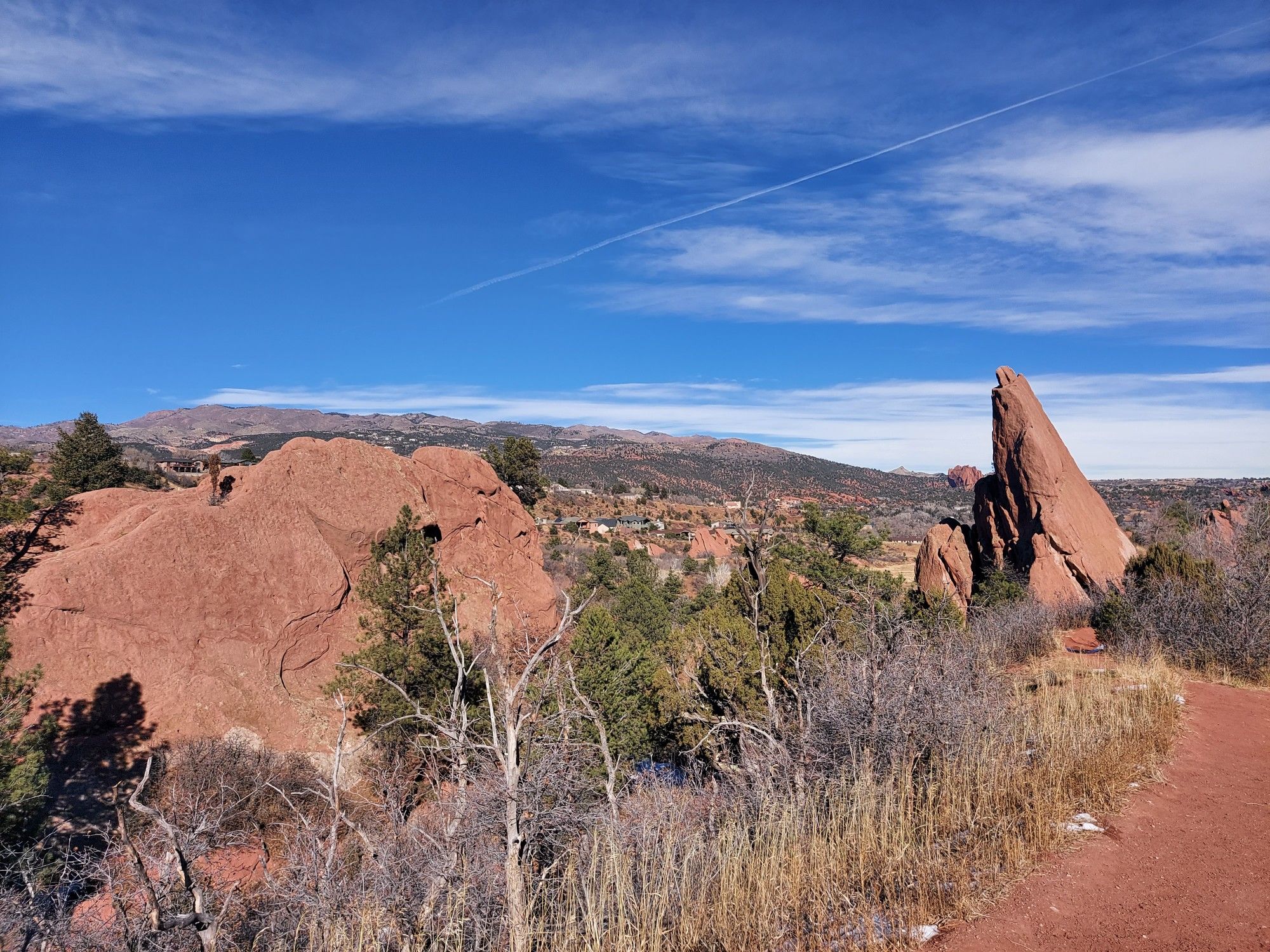 Red rock formations and trees beside a dirt path under a bright blue sky. - Contemplative Trail, Roundup Trail, Mesa Trail Loop