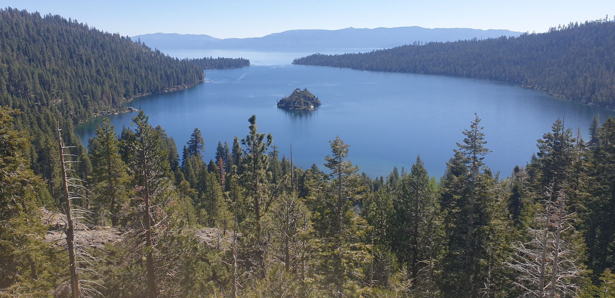 Scenic view of a large blue lake with a small island, surrounded by pine forests. - West Shore Trail – Emerald Bay View loop from Dollar Point