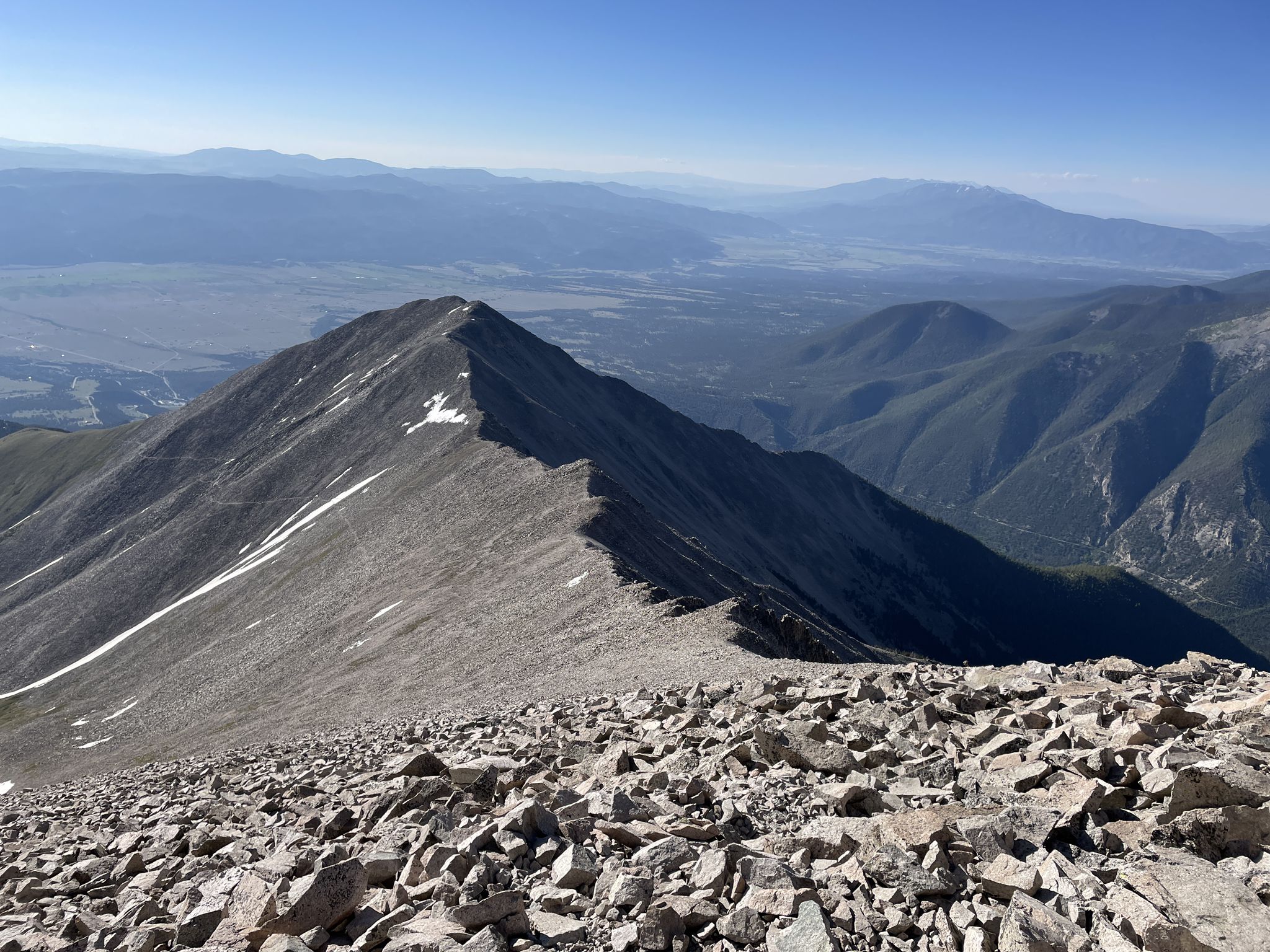 Steep, rocky mountain ridge under a clear sky with distant valleys. - Mount Princeton Trail