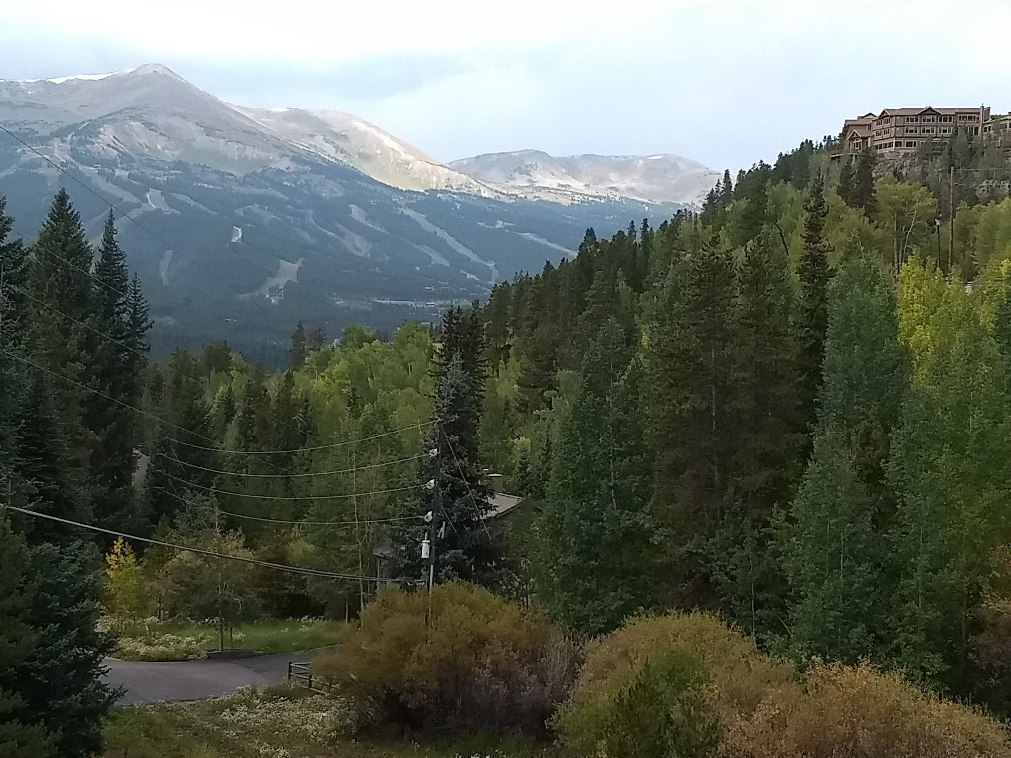 Overcast mountain landscape with dense forests and a distant building on a ridge. - Breckenridge Overlook loop