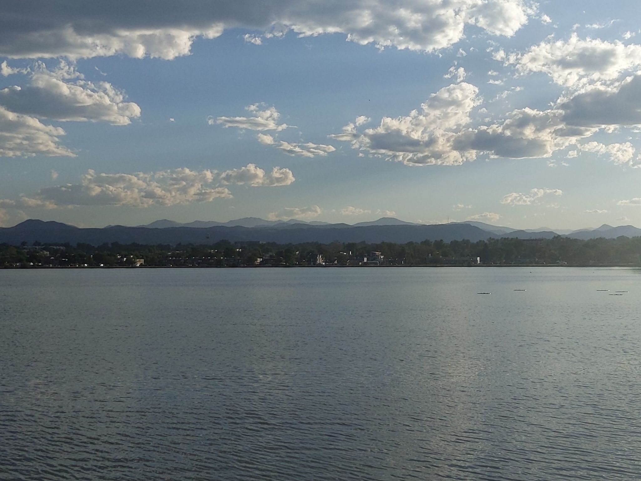 Wide lake with distant town and mountains under a partly cloudy sky. - Hiking loop from Edgewater