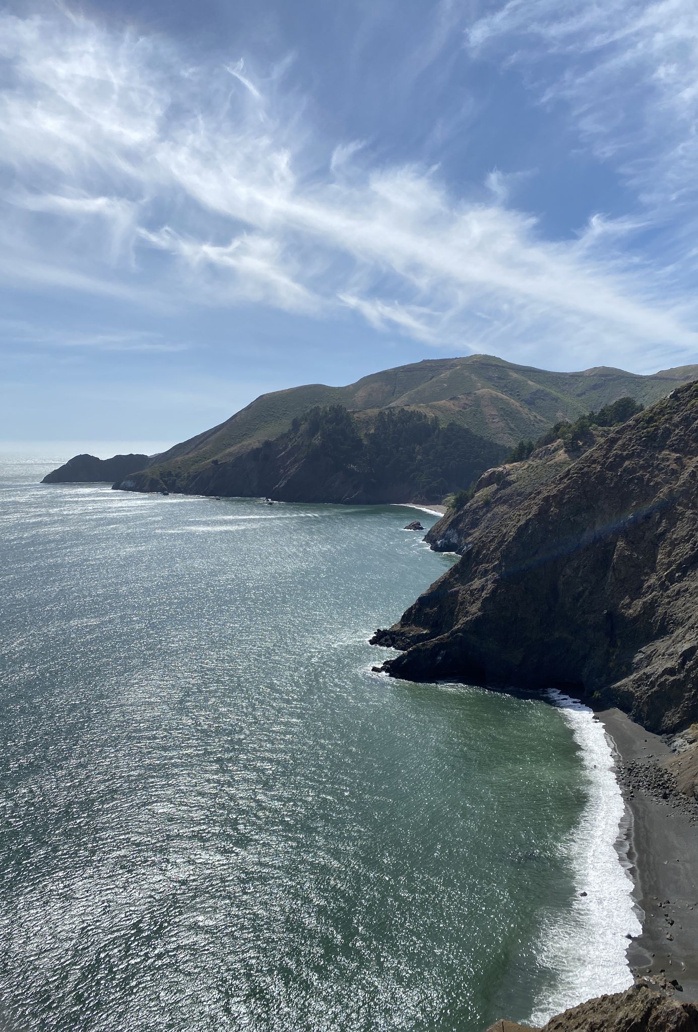 Dramatic coastal cliffs meet the ocean under a partly cloudy sky. - Bay Area Ridge Trail: Golden Gate Bridge