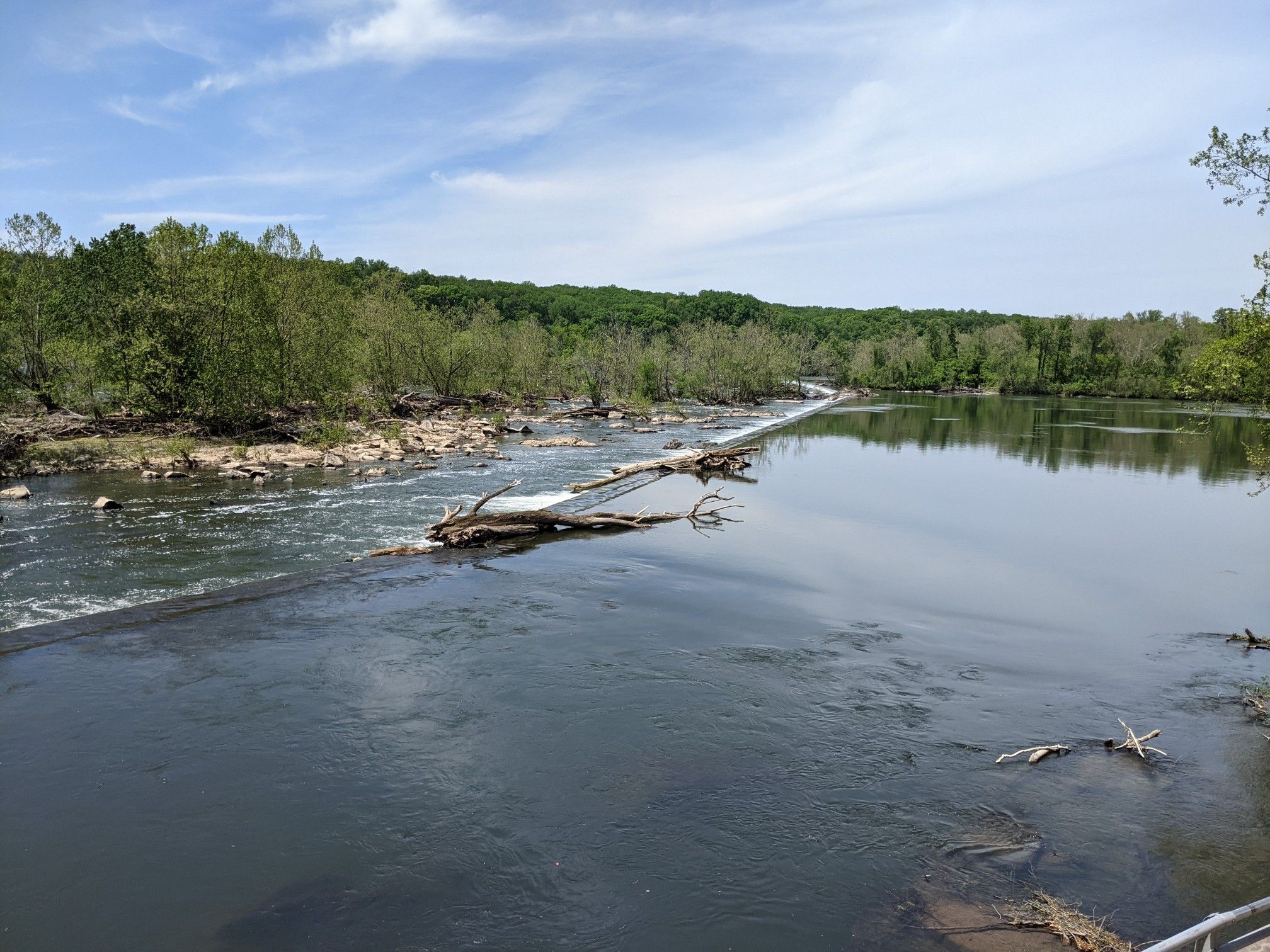 River with a rocky weir, green trees, and a bright blue sky with wispy clouds. - Swains Lock – Pennyfield Lock loop from Falls Road Golf Course