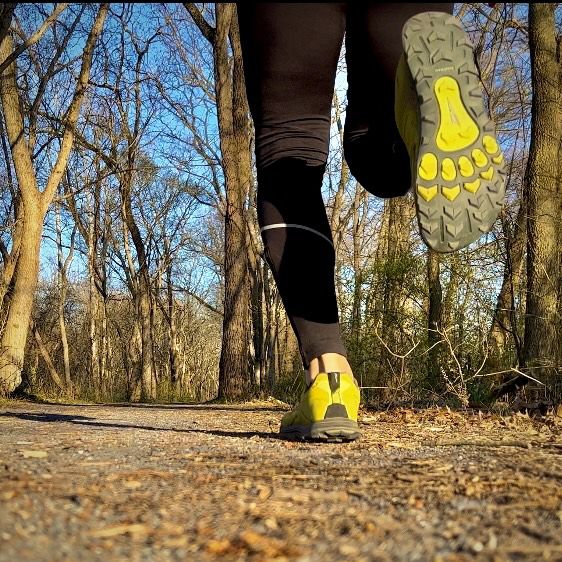 A person's legs and feet running on a dirt path through a sunny forest. - C&O Canal Trail: Edwards Ferry to Sycamore Landing