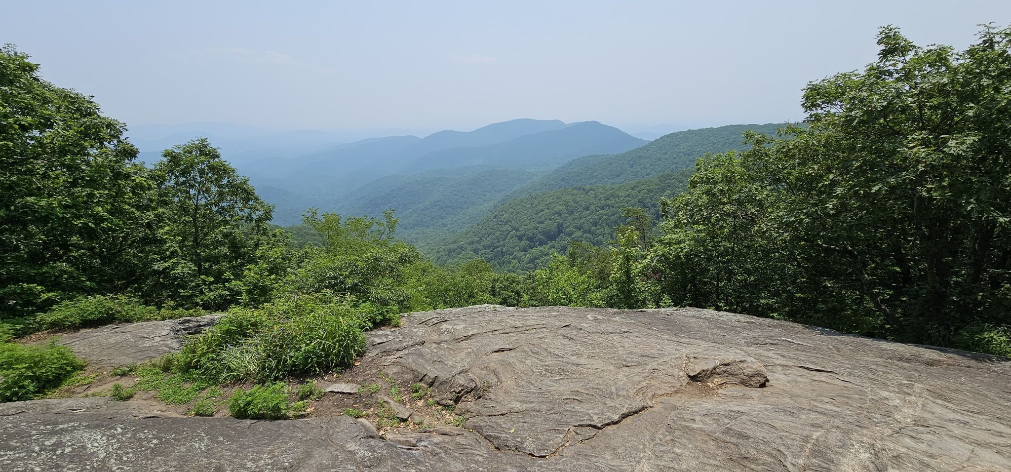Hazy, forested mountain range viewed from a rocky overlook under an overcast sky. - Appalachian Trail to Preachers Rock