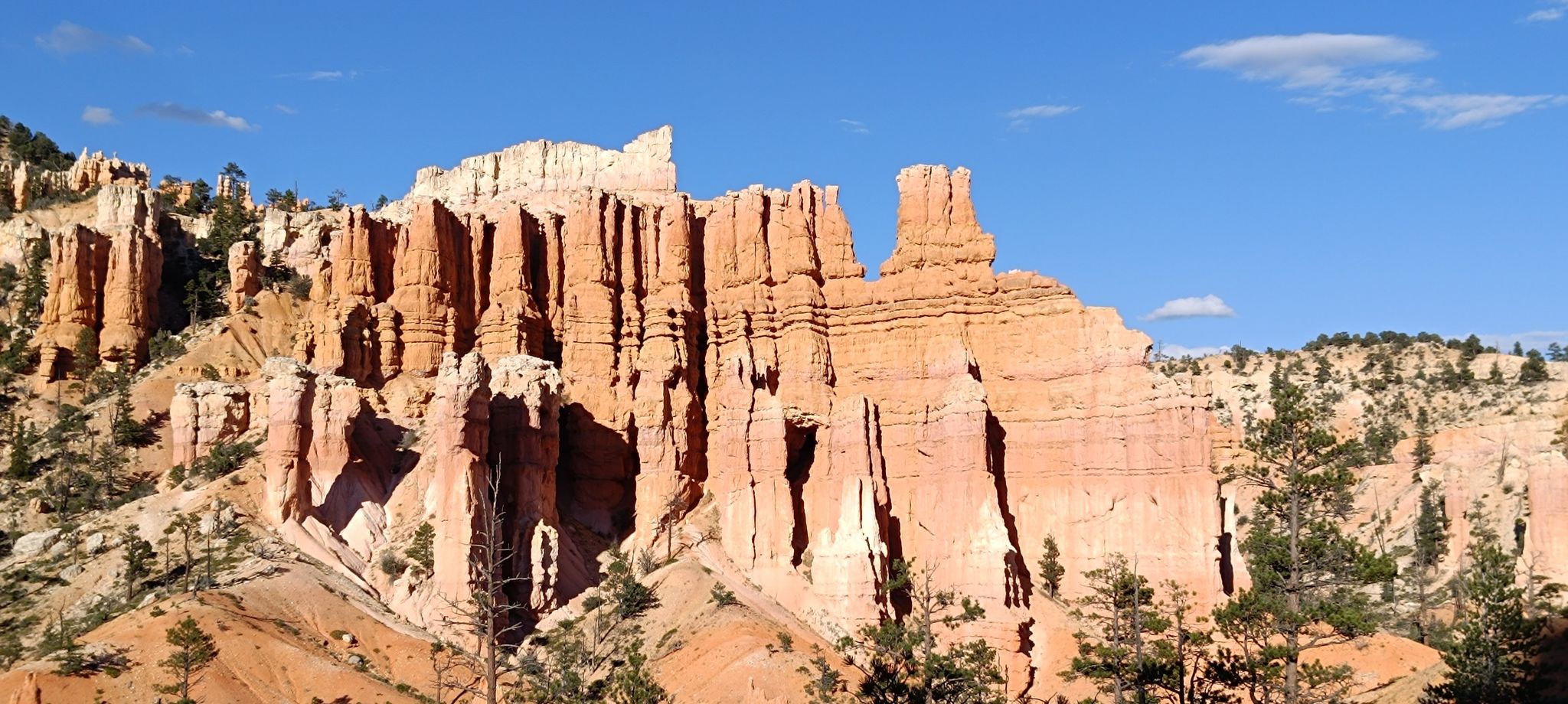 Towering red and white rock formations under a clear blue sky. - Red Canyon Arch – Red Canyon Bicycle Trail loop from Bryce Canyon City