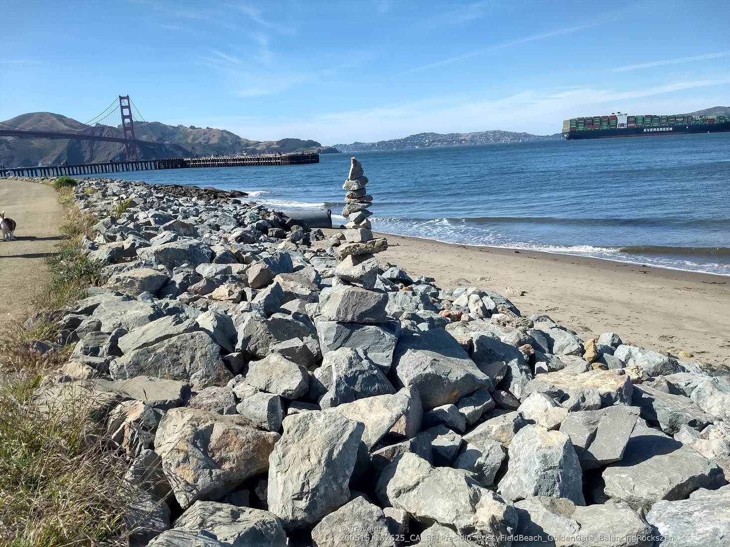 Rocky beach with a rock cairn, distant red bridge, and large ship. Sunny. - Rincon Park – Ferry Building loop from Le Conte
