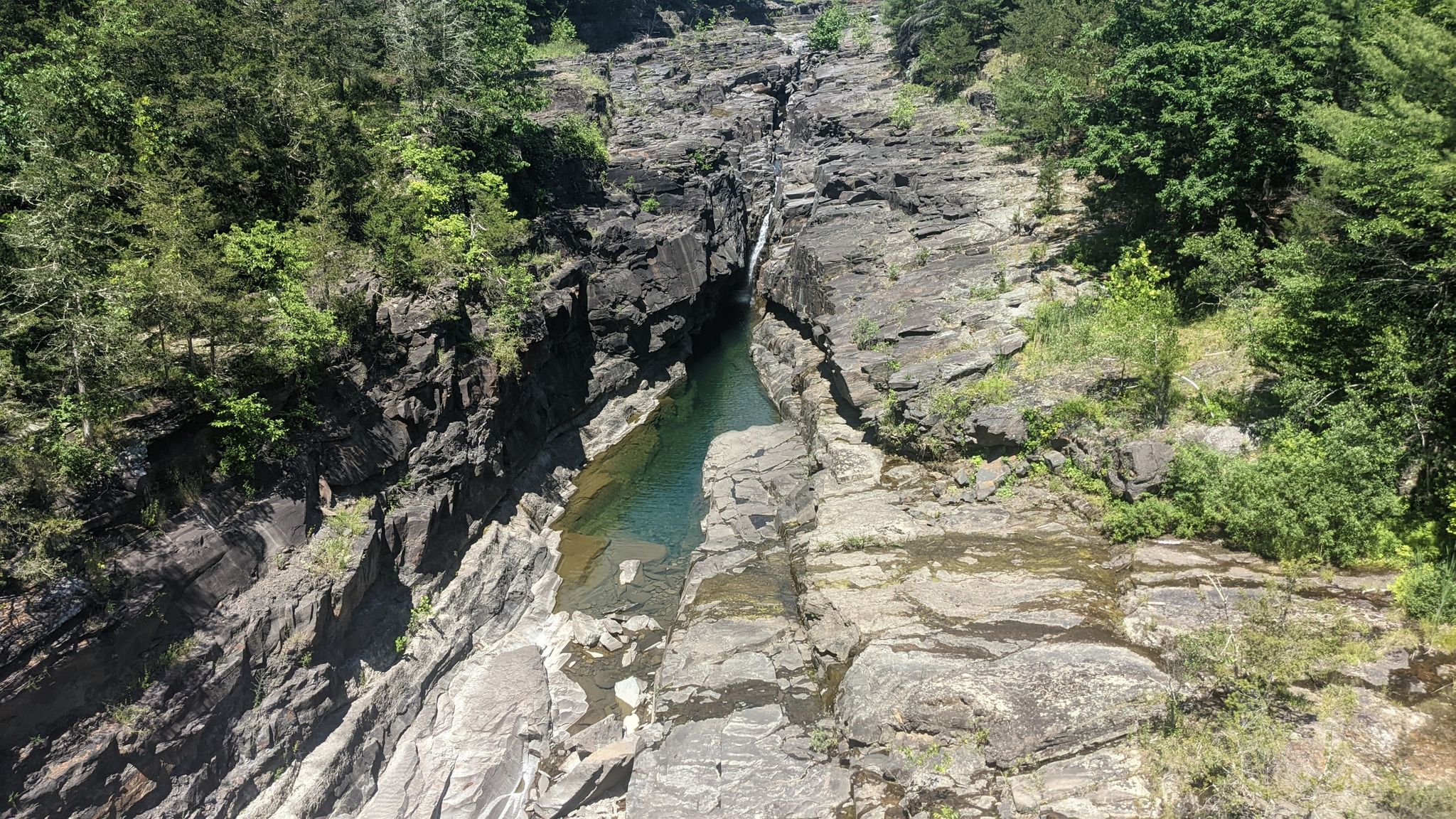 Deep, rocky gorge with a narrow river and lush green trees. - Small Ashokan Gorge loop from Stone Ridge