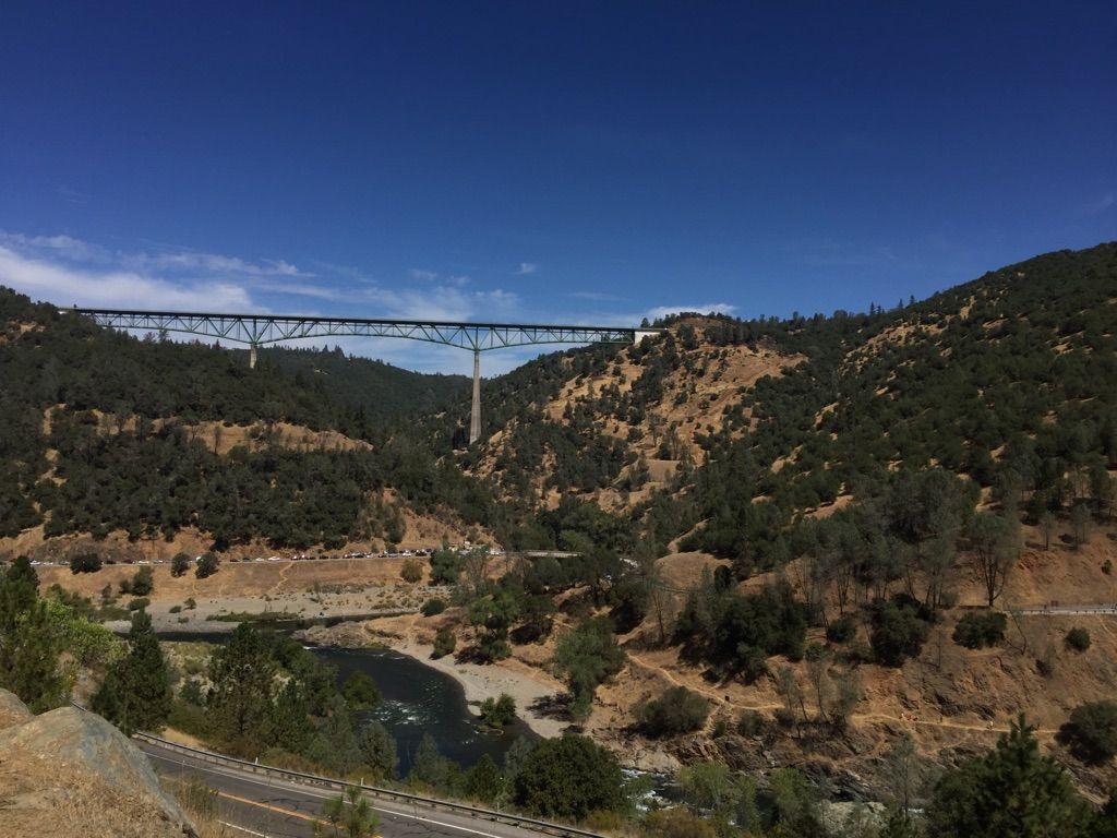 A long, tall bridge spans a wide, dry canyon under a clear blue sky. - Western States 100 Endurance Run