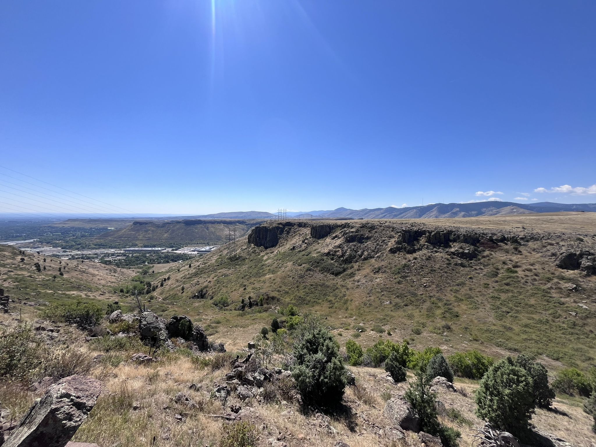 Sunny view of a vast valley with cliffs and distant mountains. - Mesa Top and Cottonwood Canyon Loop