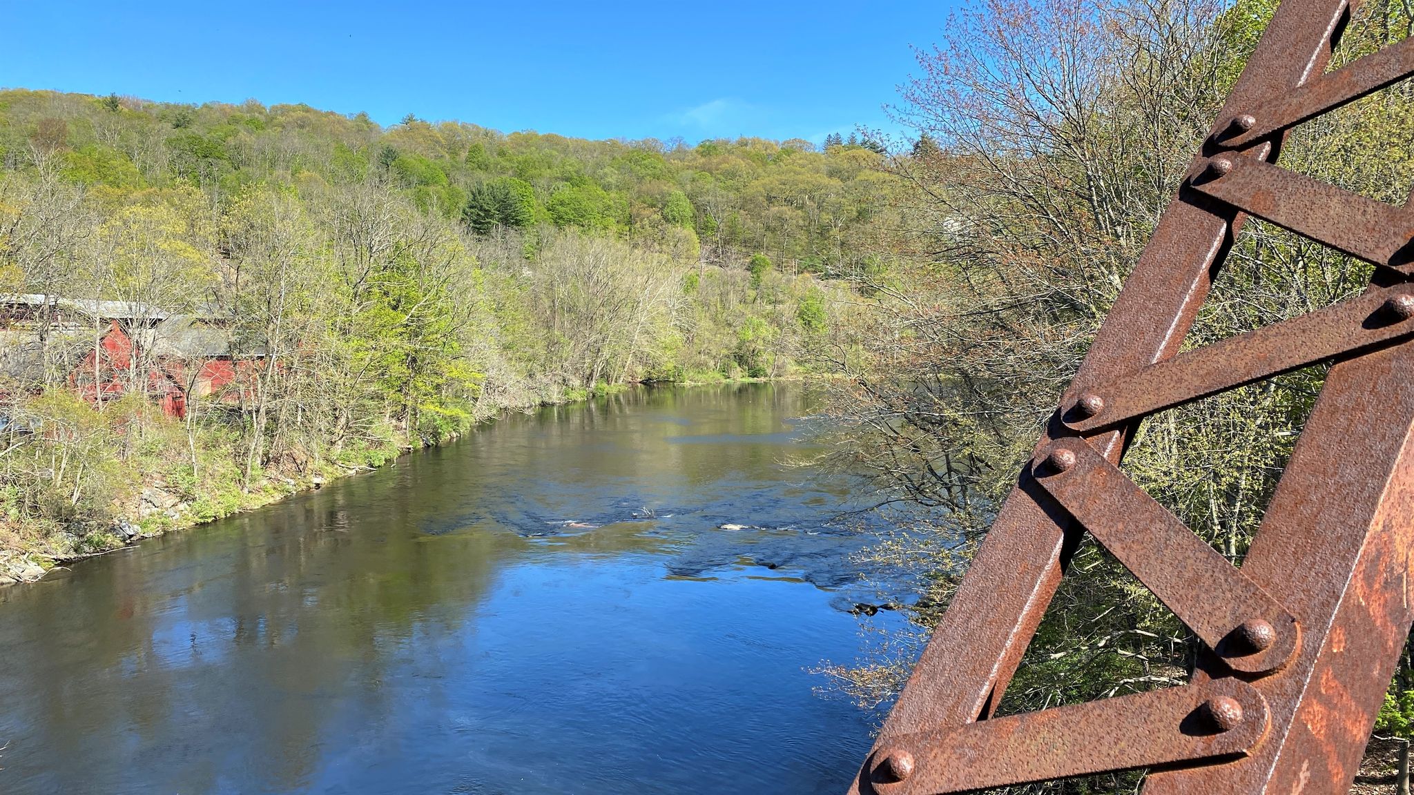River flowing through a wooded valley, seen from a rusty metal bridge. - Farmington River crossing loop from Collinsville Historic District