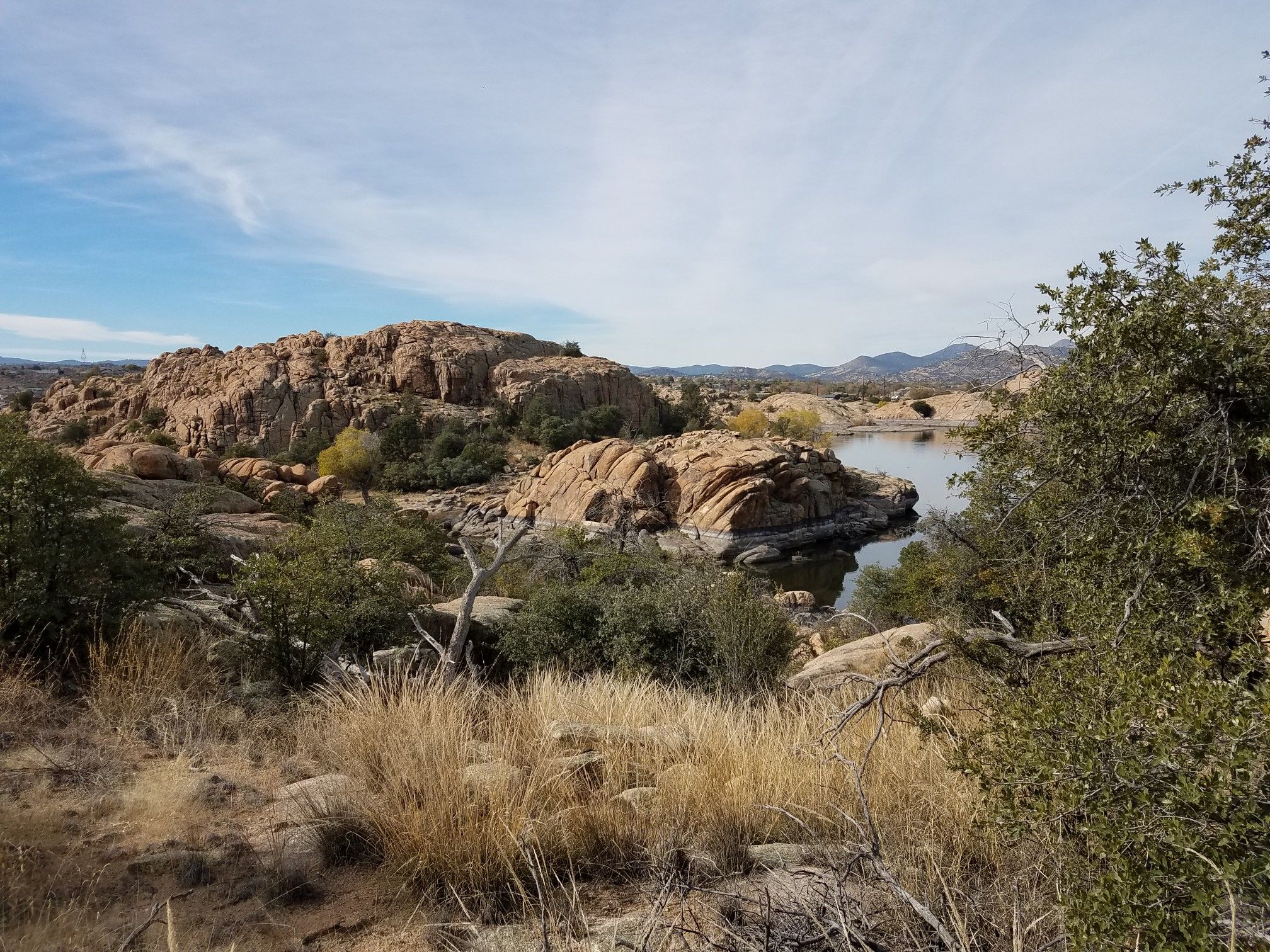 Expansive view of rocky hills, dry grass, and a serene lake. - Willow Lake Loop Trail