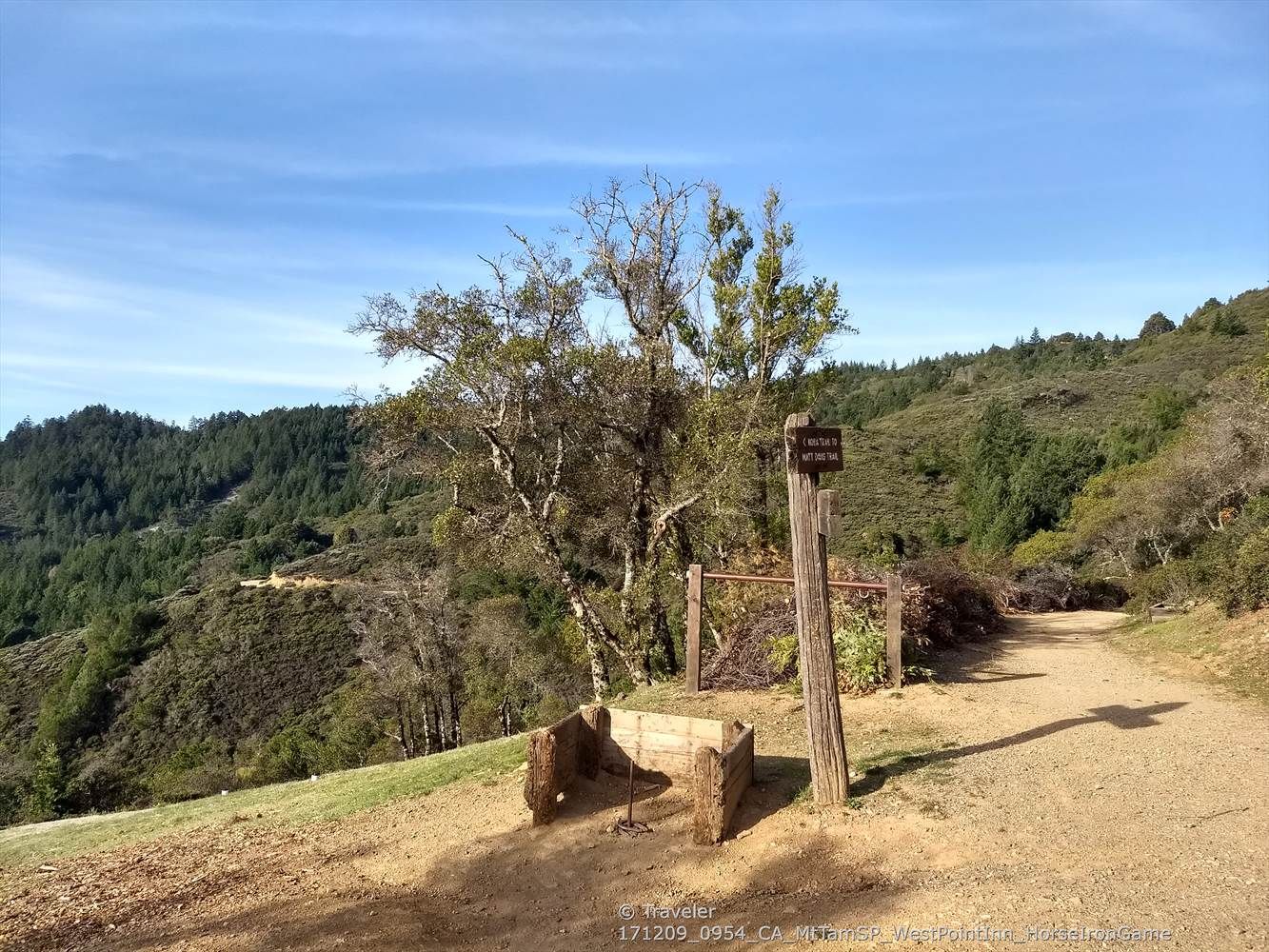 Sunny dirt path with a wooden signpost and benches on a hillside. - Old Mine Trail (lower) 🌲 loop from Mill Valley