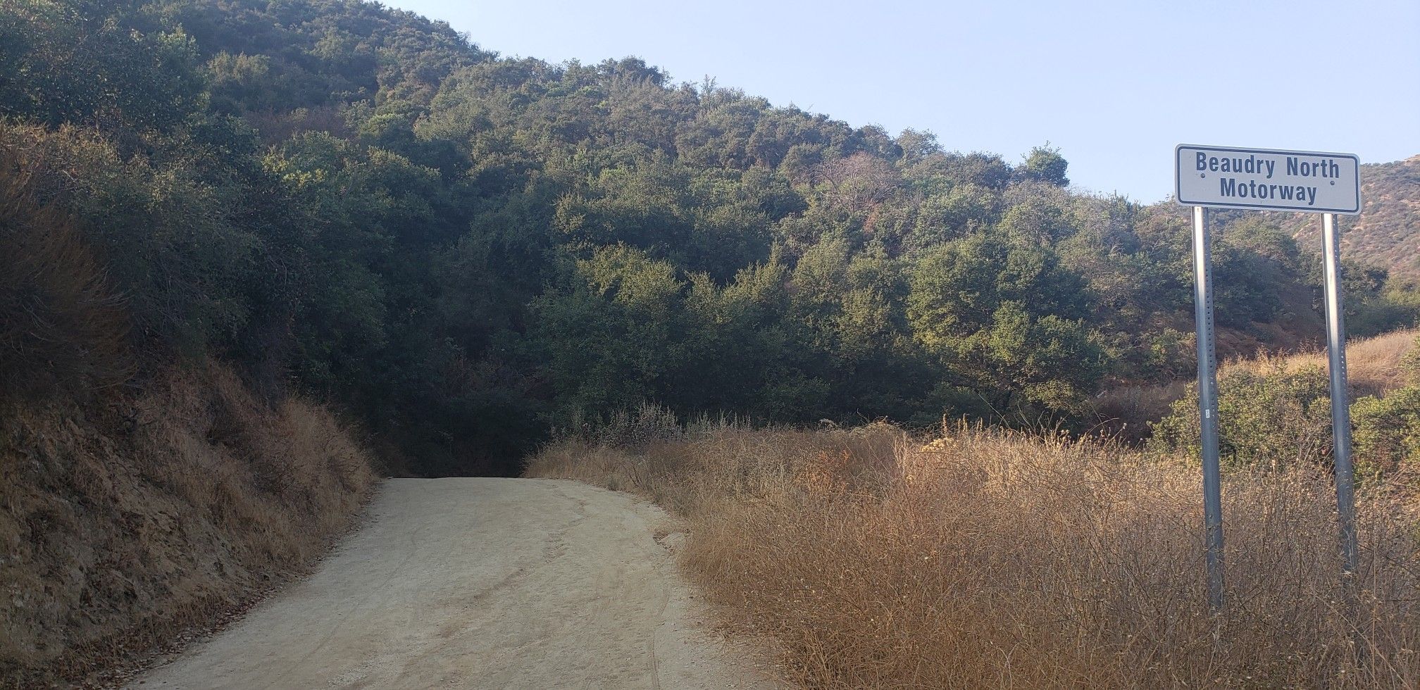 Dirt road leading into a wooded hillside, with a sign on the right. - Brand Park – Beaudry North Trail loop from San Rafael Hills Open Space
