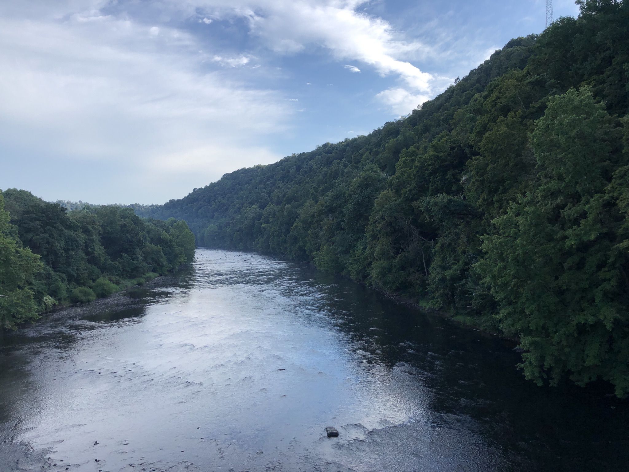 A wide river reflects the sky, flanked by dense green forested hills. - Confluence loop from Garrett