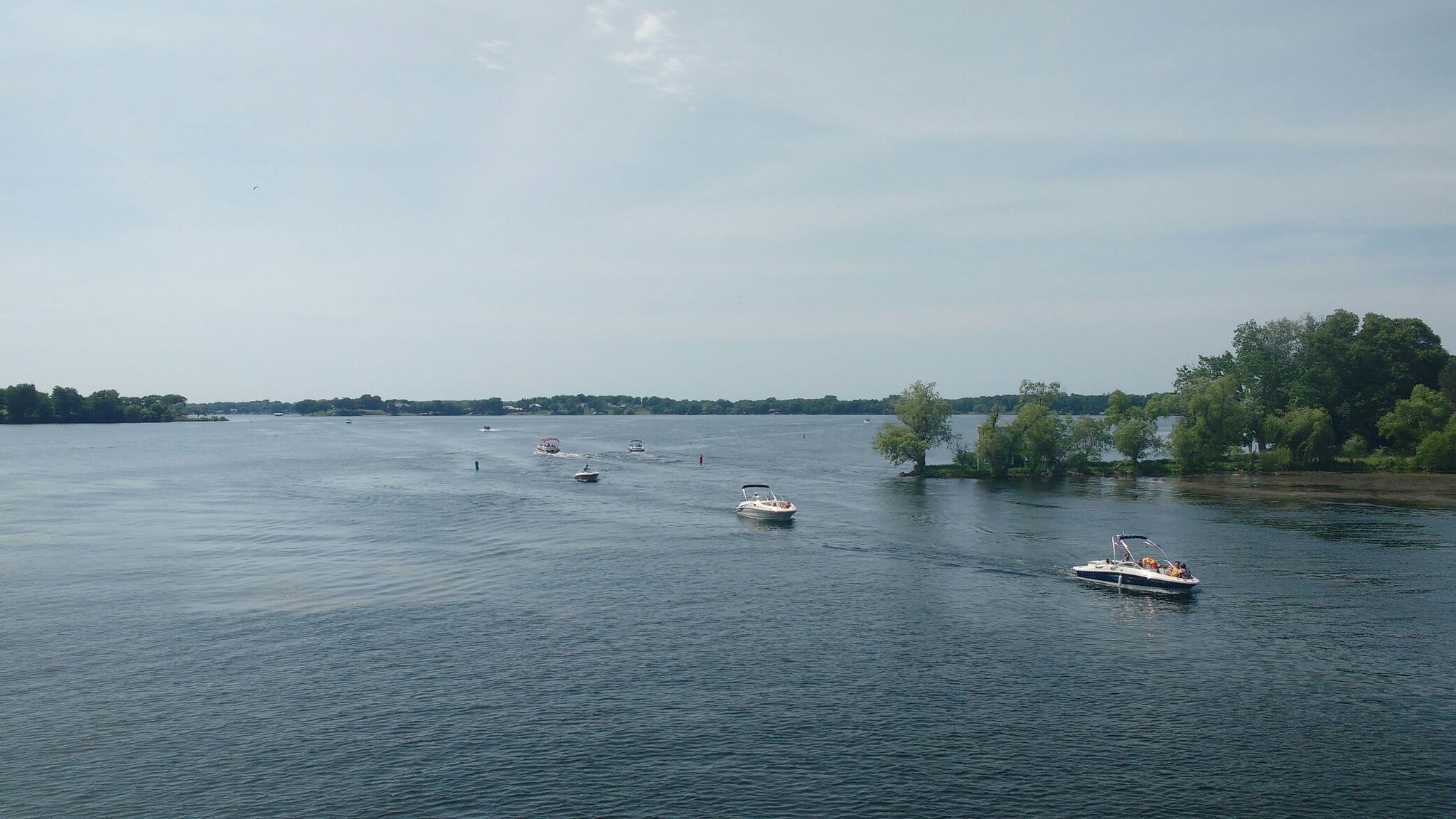 Several boats on a wide body of water with distant treelines under cloudy sky. - Bederwood Park – Arcola Trestle Bridge loop from Lowry Woods Nature Conservation Area