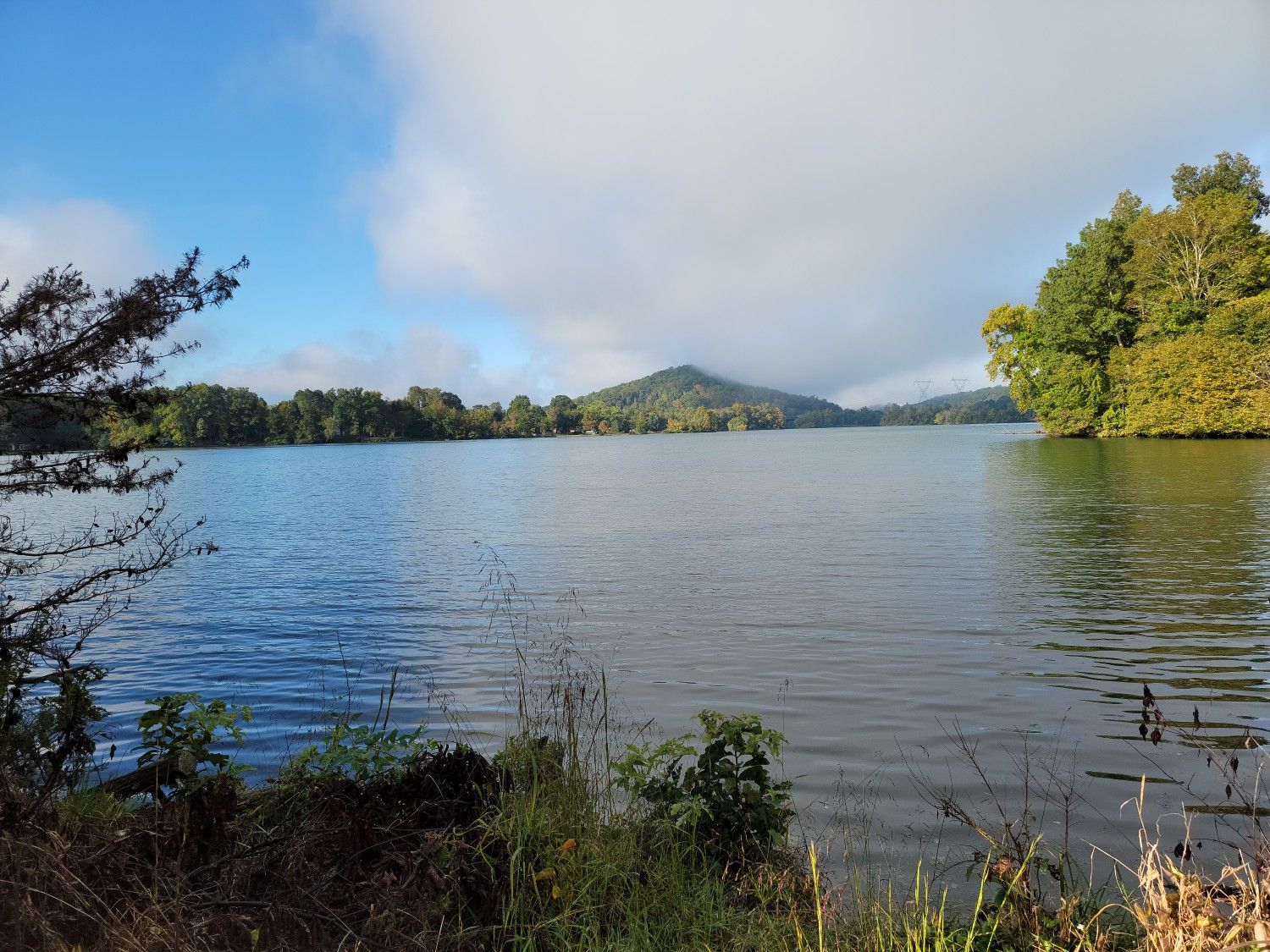 A serene lake with a distant mountain under a partly cloudy sky. - Haw Ridge Park Loop