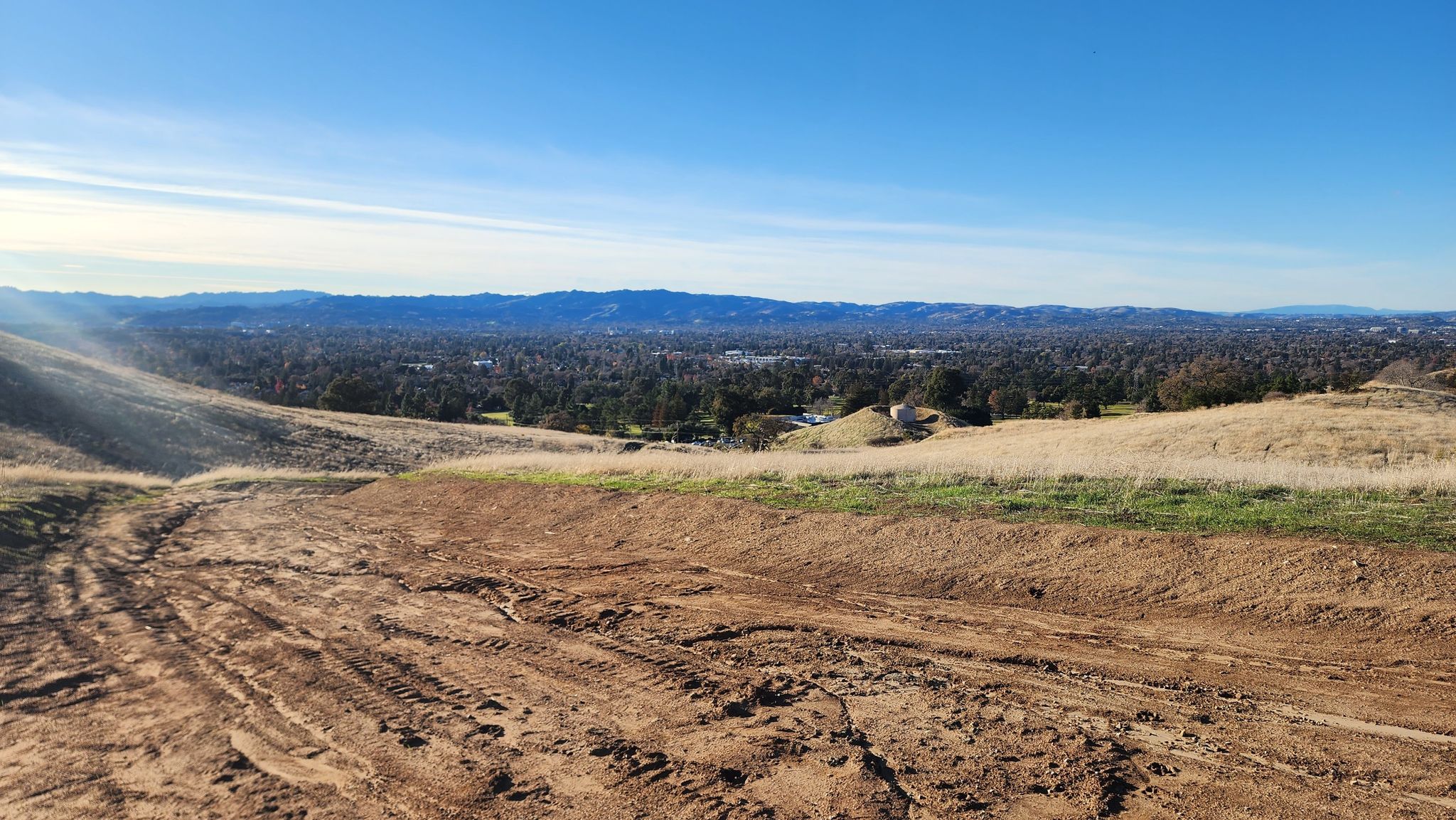 A wide view of a valley city from a dirt hillside under a clear sky. - Paraiso, Manzanita and Ohlone Trail Loop