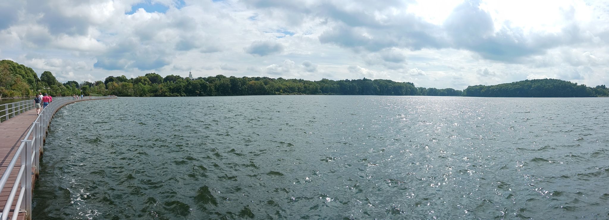 Panoramic view of a wide lake with a boardwalk and distant people. - Lake Williams Boardwalk loop from Marlborough