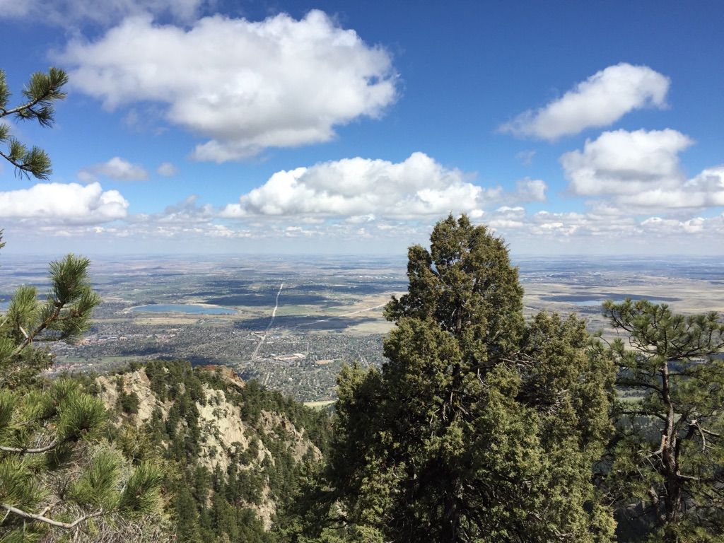 Panoramic view of a valley and plains under a blue, cloudy sky. - Green Mountain West Ridge Trail