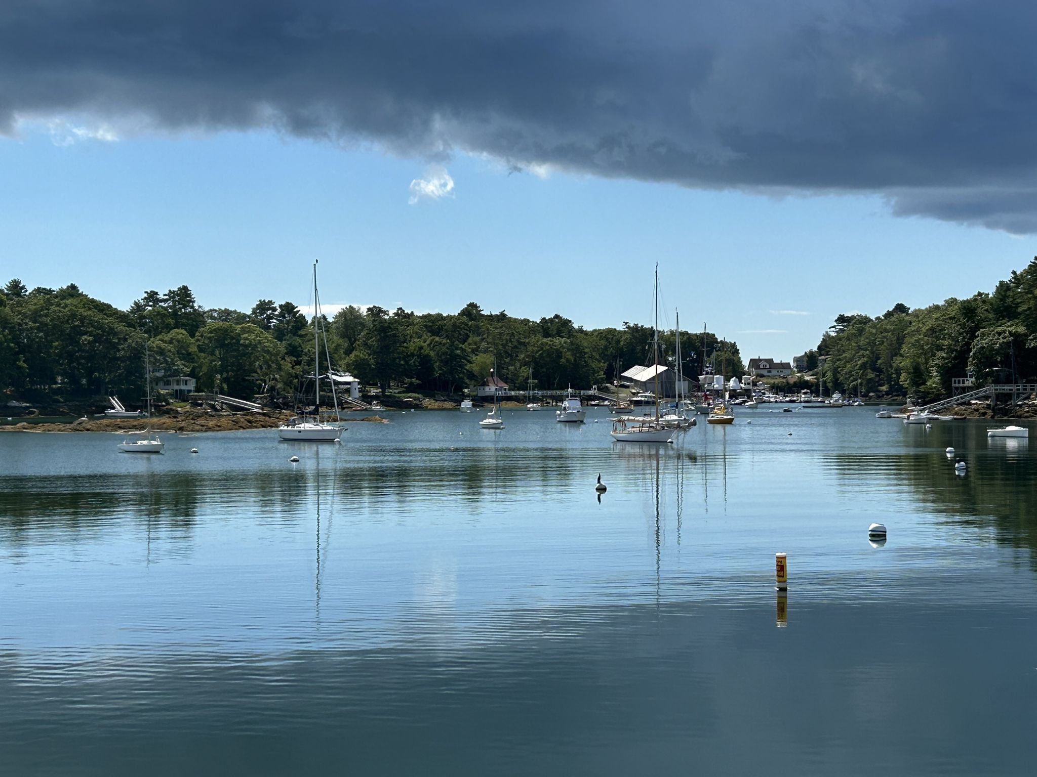 Boats anchored in a calm bay under a partly cloudy sky. - Trevett Country Store – Boothbay Harbor loop from Hodgdon Island
