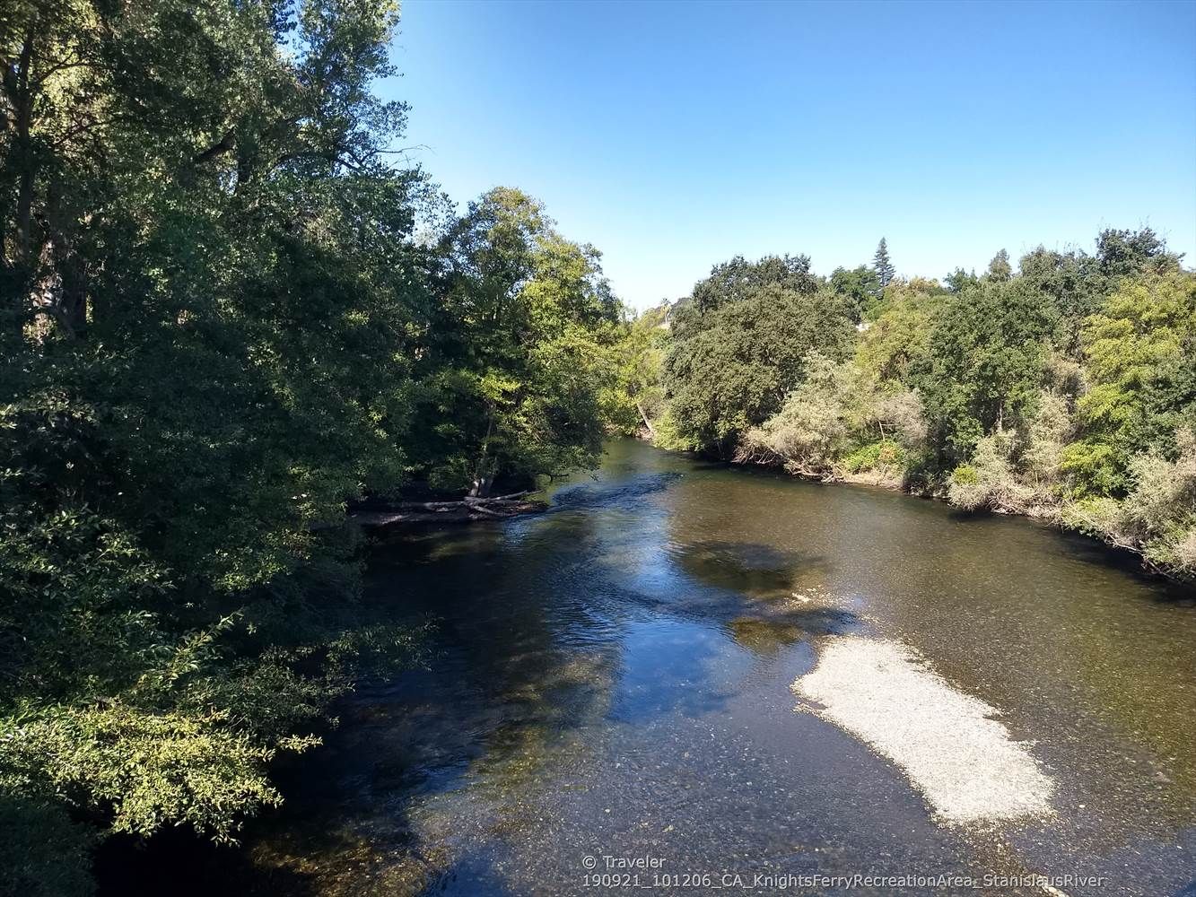 Clear river flowing between lush green trees on a bright sunny day. - Orange Blossom Road – Horseshoe Road Recreation Area loop from Oakdale