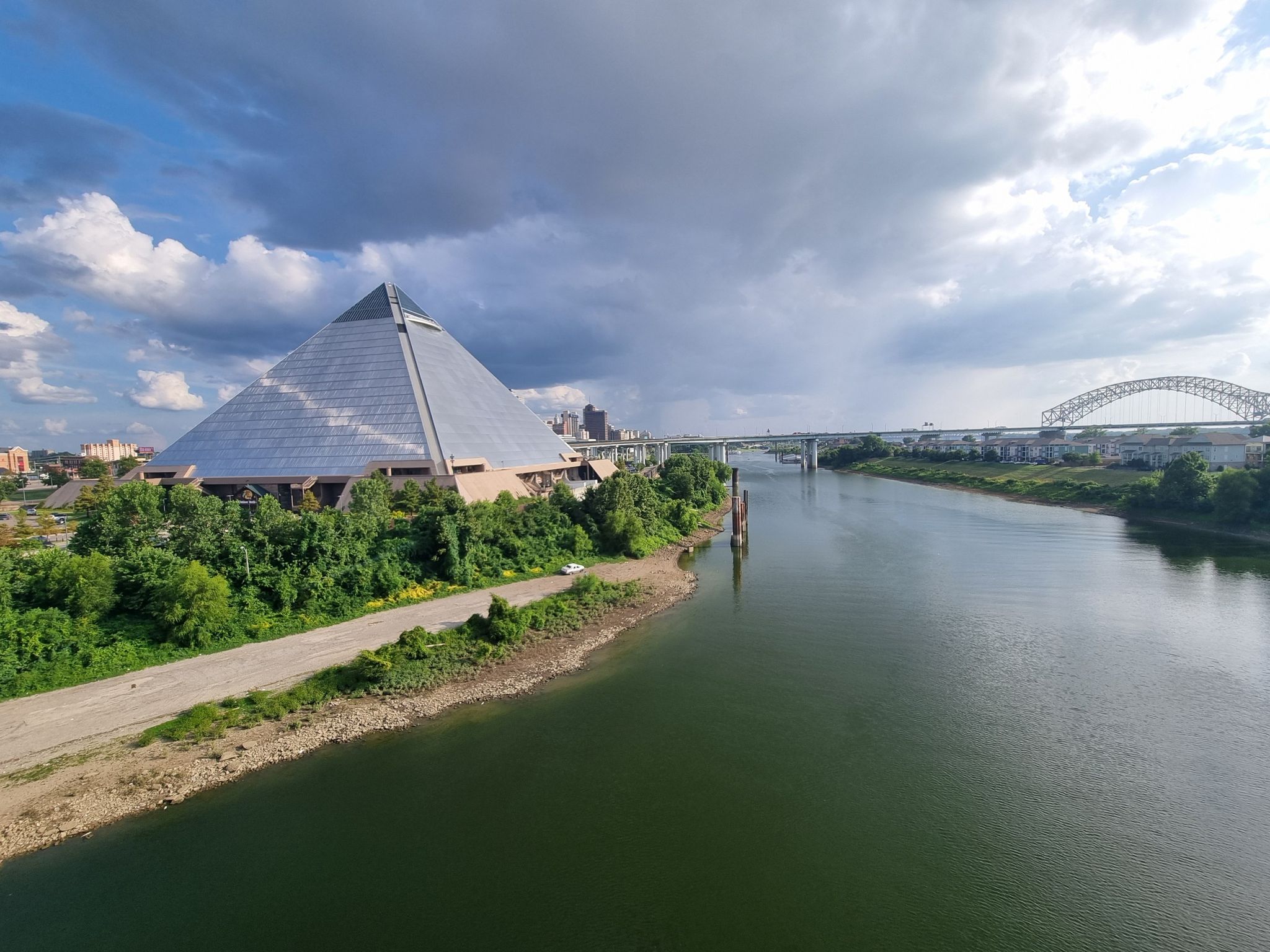 Large pyramid building beside a wide river under a cloudy sky. - Fire Museum of Memphis – Mississippi River Walk loop from Memphis Central Station