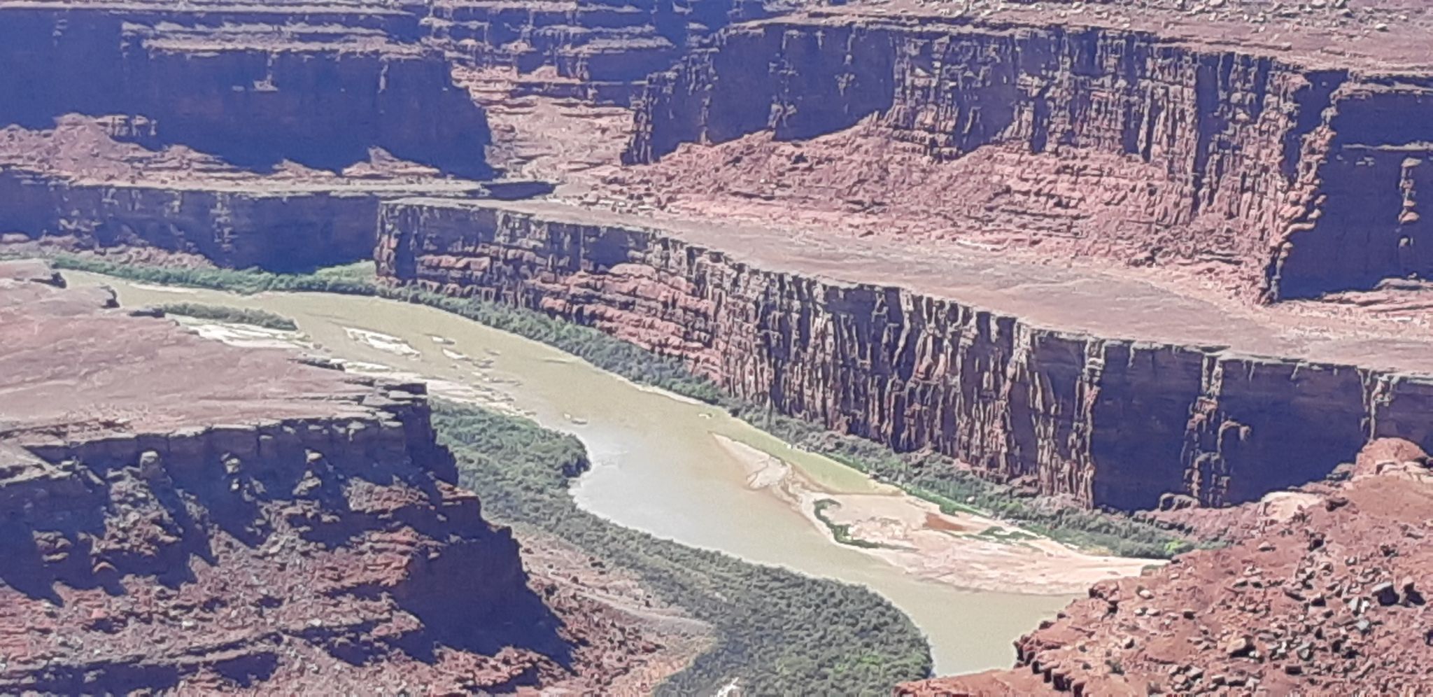 Close-up of a winding river through a deep, layered canyon. - East and West Rim Loop
