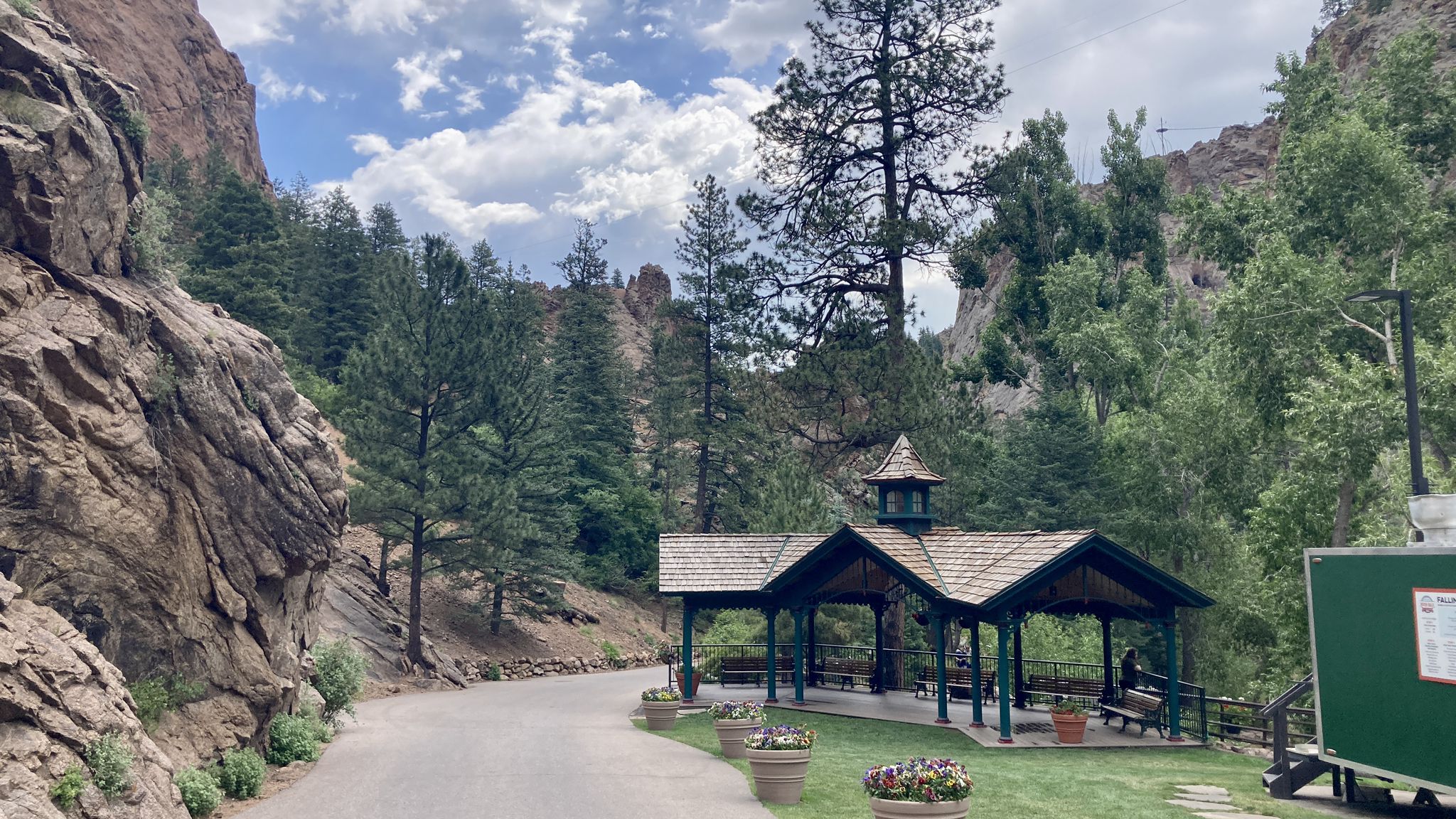 A charming open-air pavilion sits beside a paved road in a rocky canyon. - Seven Falls to Inspiration Point