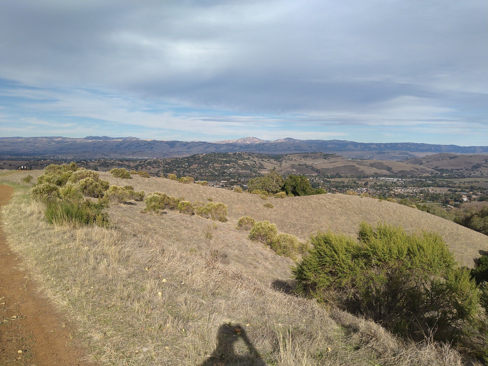 Dirt path on a dry hillside overlooking a distant city and mountains. - Santa Isabel Shaft – Randol Trail Junction loop from Almaden Quicksilver County Park
