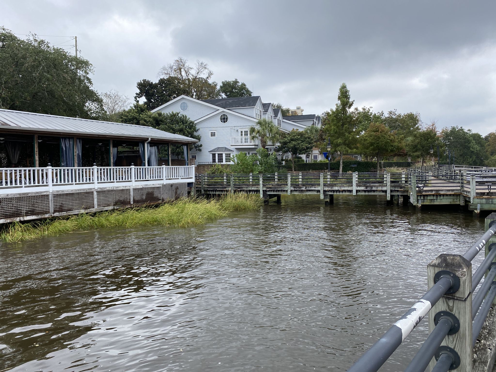 Waterfront buildings and docks next to a river under an overcast sky. - Wilmington History Museum – Wilmington Riverwalk loop from Wilmington