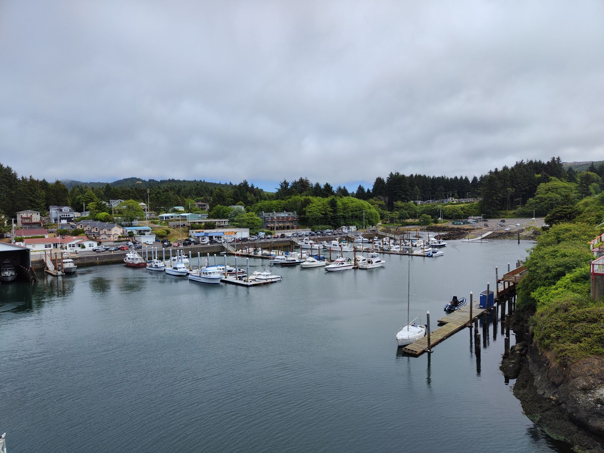 Overcast view of a marina filled with boats, surrounded by a coastal town. - Oregon Coast Trail: Depoe Bay Loop